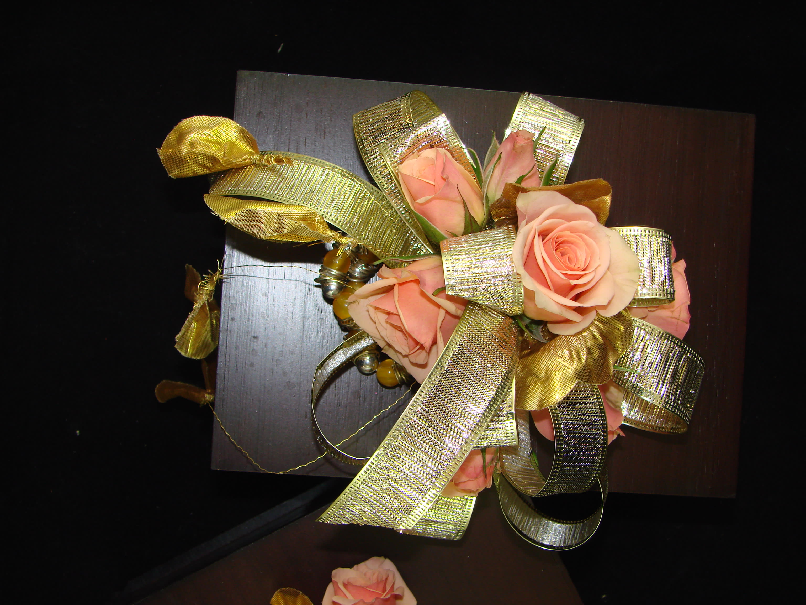 All That Glitters Corsage - Peach Spray roses tucked between shimmering gold ribbon