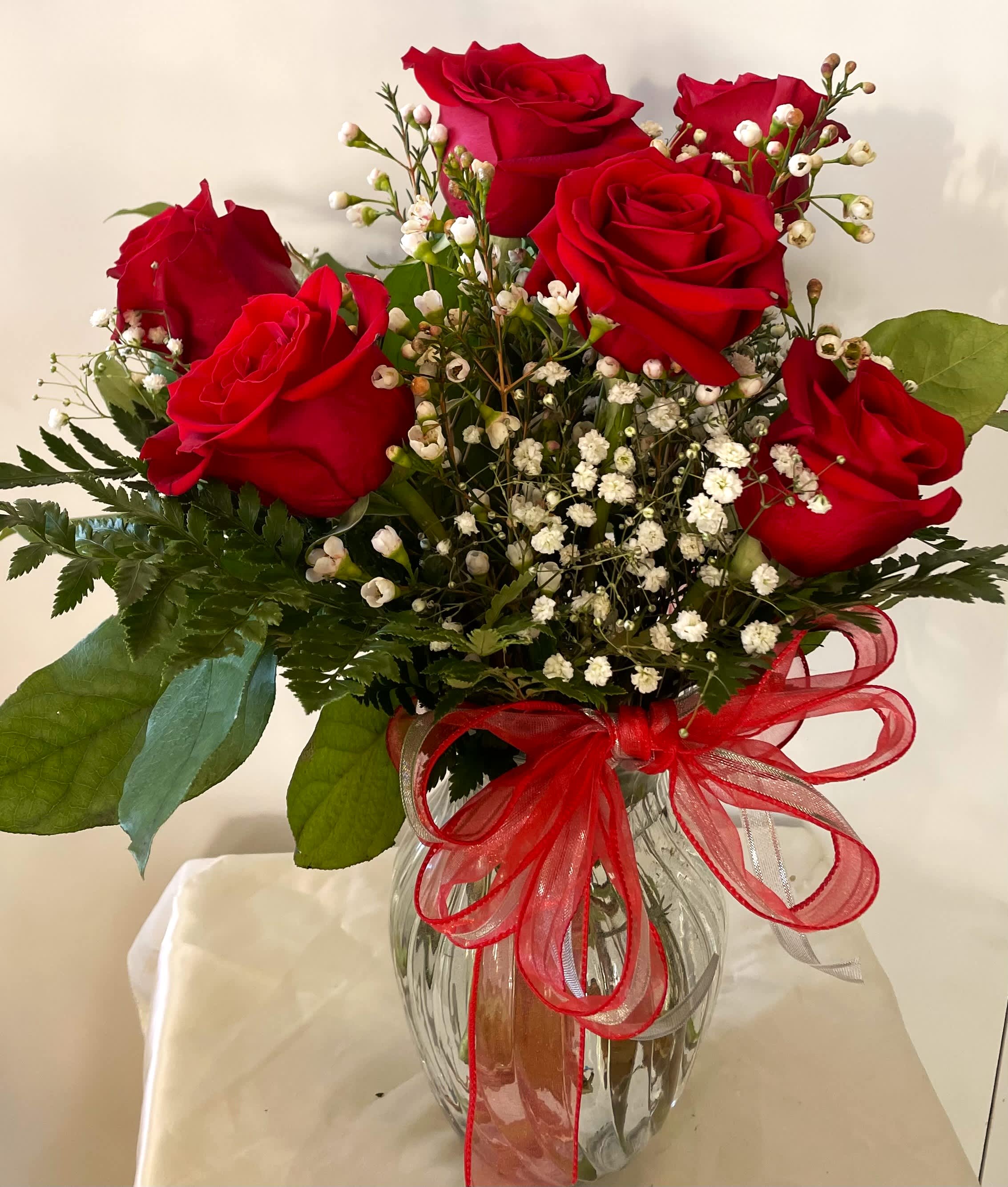 Six Red Roses in a Vase Six Red Roses in a Vase - A classic design of six long-stemmed red roses arranged with million star babies breath in a clear glass vase.