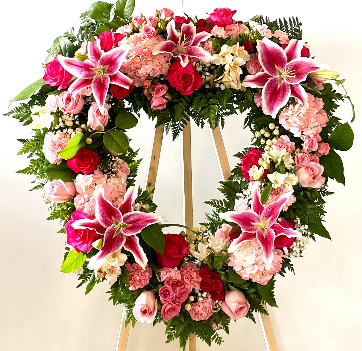 HEART FULL OF GRACE HEART FULL OF GRACE - BEAUTIFUL OPEN HEART TRIBUTE STANDING SPRAY IN VARIETAL SHADES OF PINK. APPROXIMATELY 48" TALL ON EASLE, AND 32-36" IN WIDTH.