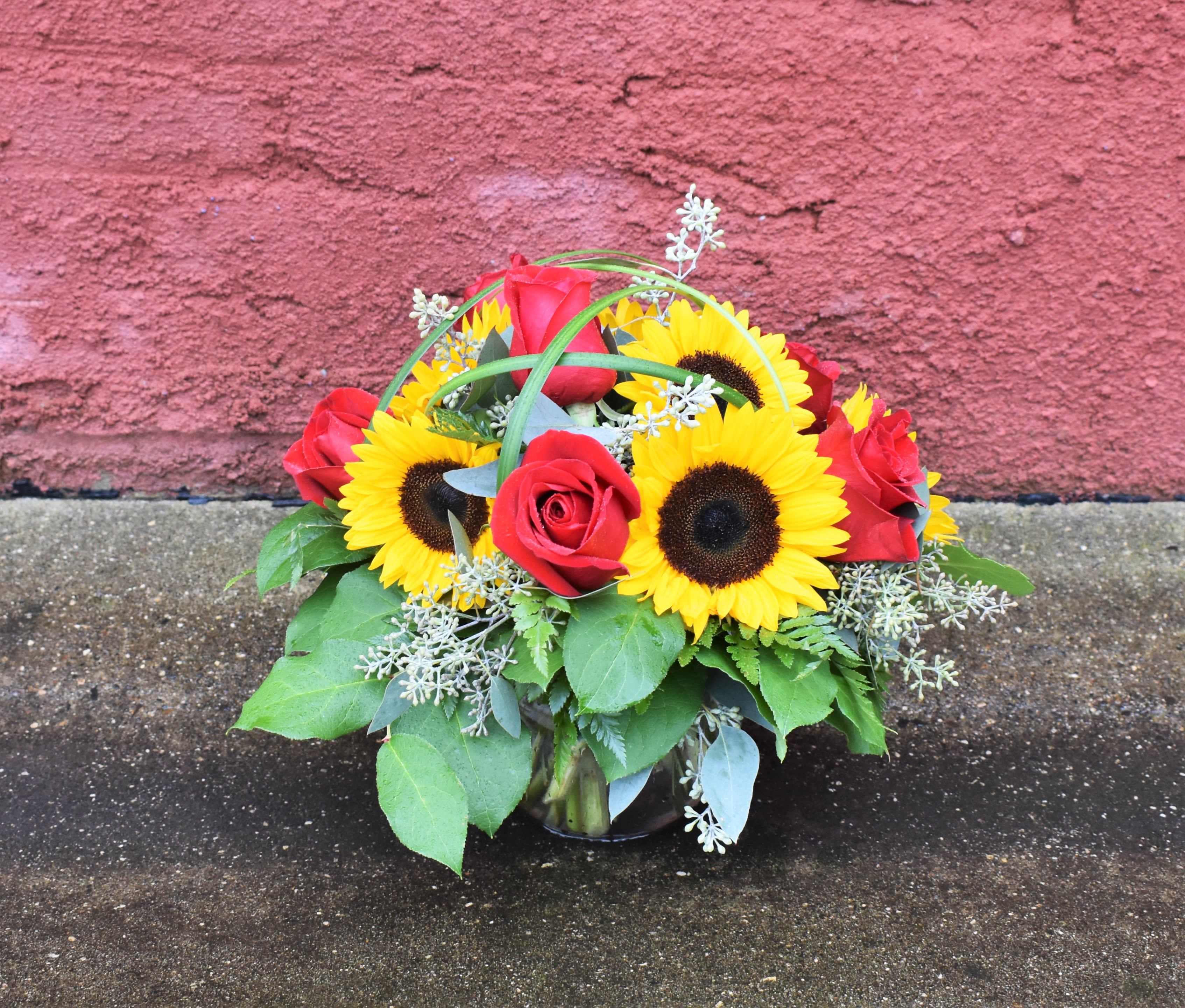 Loving the Sunshine - A  clear glass vase is brimming with sunflowers &amp; red roses and accented by textural eucalyptus &amp; grasses. Perfect for celebrating any occasion in the late summer &amp; fall! 