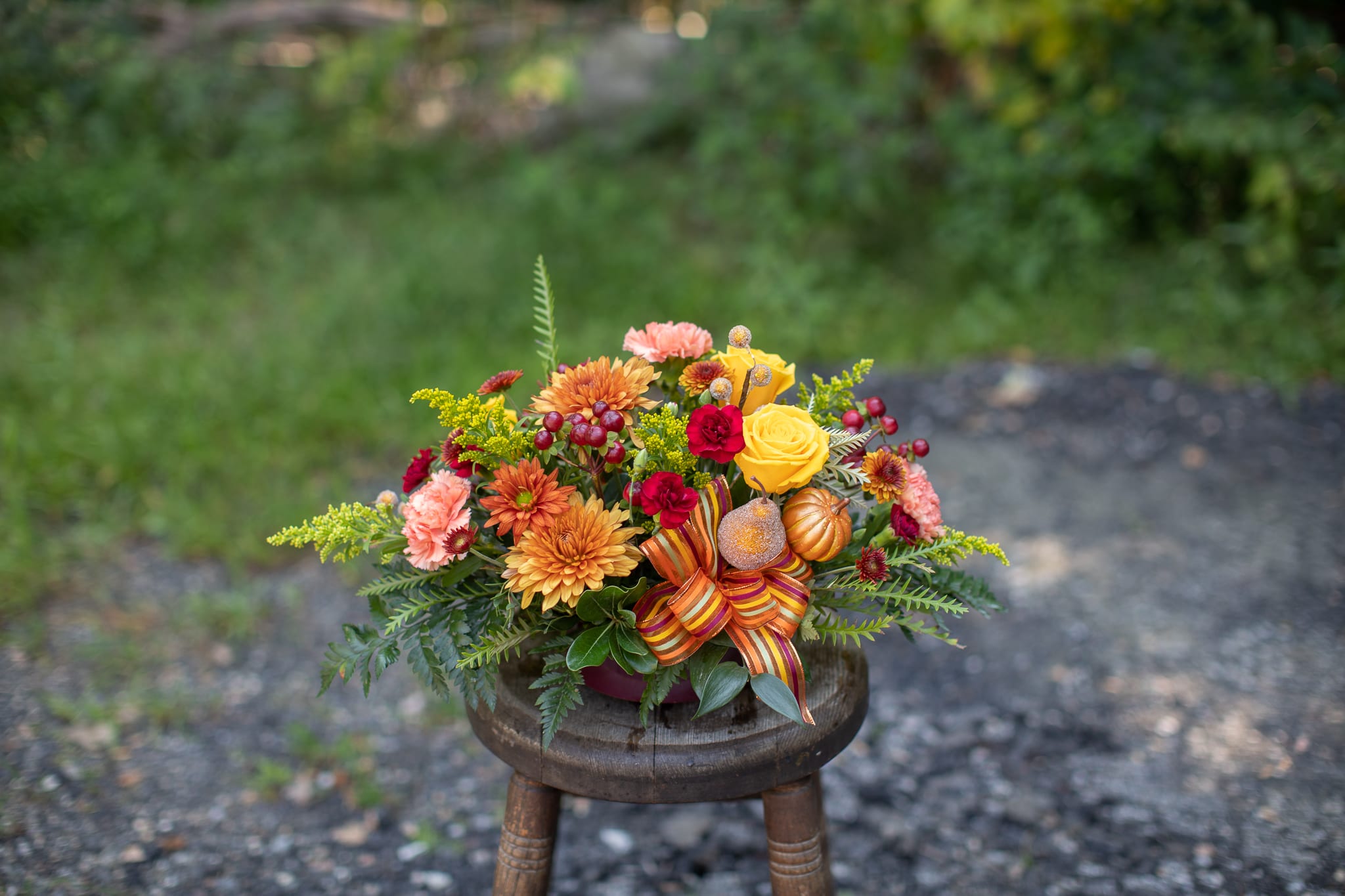 Harvest Bowl - Cheerful arrangement mimicking a crop harvest gathering at the end of fall. Can be placed as a table centerpiece, or anywhere else as accent décor! Frosted pears and autumnal pumpkins bring the harvest appeal. Floral design is long and low in style, measures about 18 inches long by about 8 inches in height.  Design is doubled-sided to be aesthetically pleasing to each side of a table.  