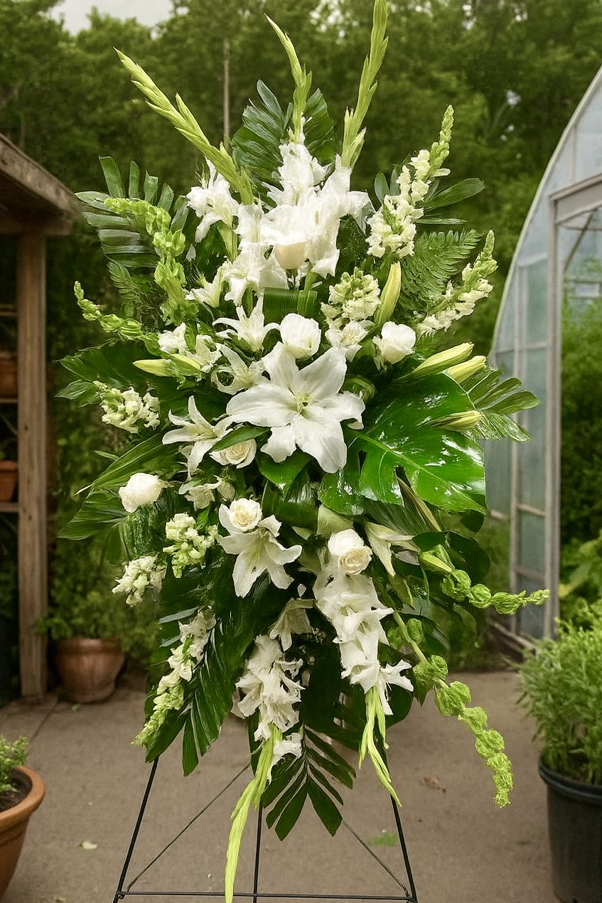 Gentle Spirit Gentle Spirit - Elegant simplicity, inspired by nature This standing spray features lush tropical greenery paired with pristine white lilies, roses, and gladiolus — a serene and graceful tribute to celebrate a life well lived and forever remembered.”