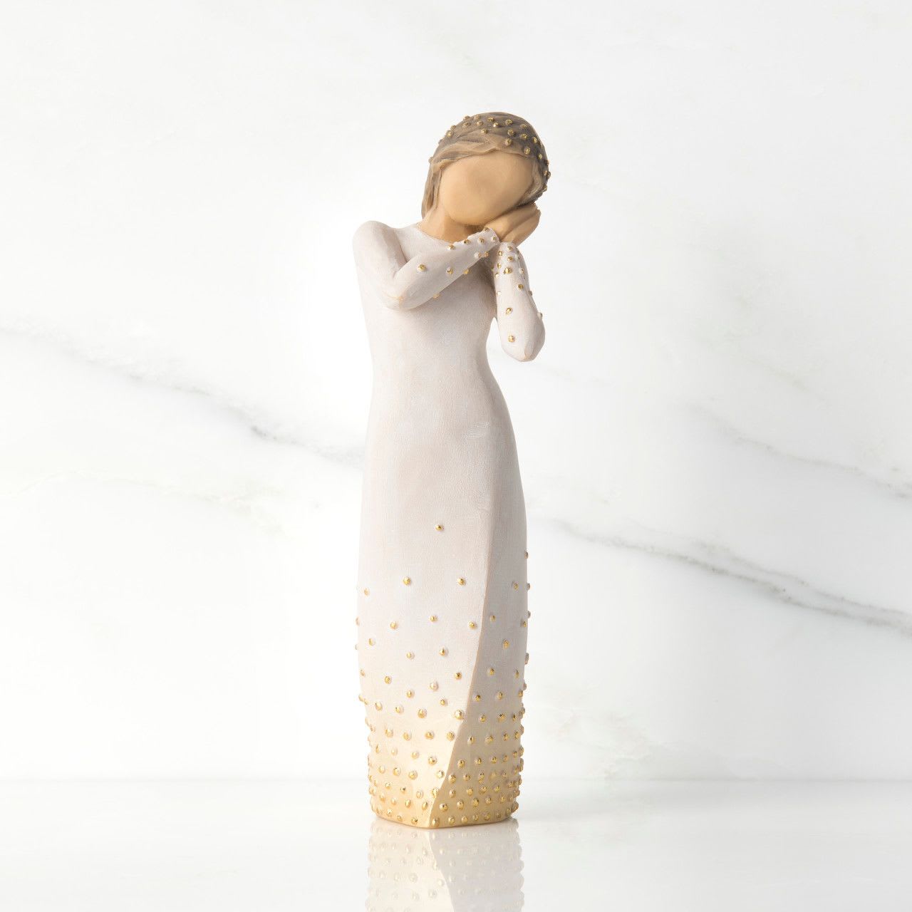 Willow Tree - WISHING... A beautiful wish for you Willow Tree - WISHING... A beautiful wish for you - 6.5”h hand-painted resin figure. Applied gold leaf Standing figure in cream dress, holding up arms to face in wistful gesture. Bottom of dress embellished with gold and gold-leaf dots Custom-designed Signature Collection Box includes enclosure card for gift-giving Dust with soft cloth or soft brush. Avoid water or cleaning solvents
