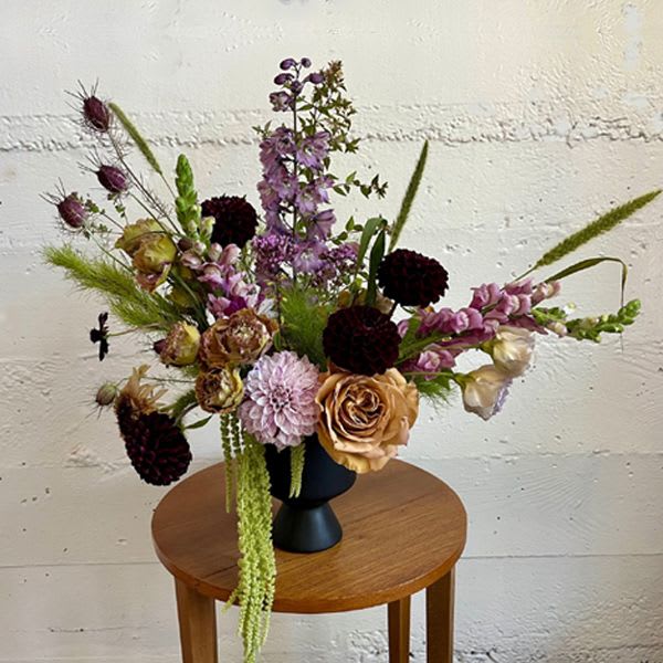 Mood Indigo Mood Indigo - Sometimes a dark and moody vibe is exactly what is called for! We pair deep dark colors with soft pastels to create a striking contemporary arrangement of seasonal blooms. PLEASE NOTE: Colors and flower varieties will vary due to season and availability but the arrangement will retain it's overall aesthetic.