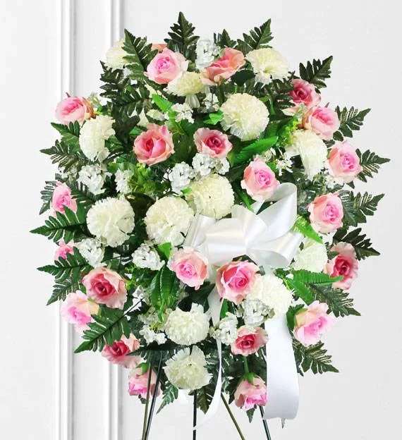 Memories Standing Spray  - A delicate blend of soft pink and pure white blooms, this standing spray conveys love, grace, and heartfelt remembrance. Accented with lush greenery, this arrangement symbolizes comfort and peace, offering a beautiful tribute to honor the memory of a cherished loved one.