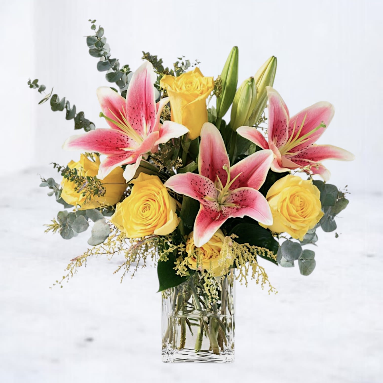 Radiant Bloom - Brighten any occasion with Radiant Bloom, a vibrant bouquet featuring sunny yellow roses and exotic pink Stargazer lilies. Accented with lush greenery and delicate red berries, this arrangement exudes joy and elegance. Perfect for celebrating birthdays, special milestones, or simply bringing a smile to someone’s day. Whiskey Wallflower offers same-day delivery in Houston and surrounding areas—order the Radiant Bloom Symphony today to add a splash of color and happiness to your celebrations!