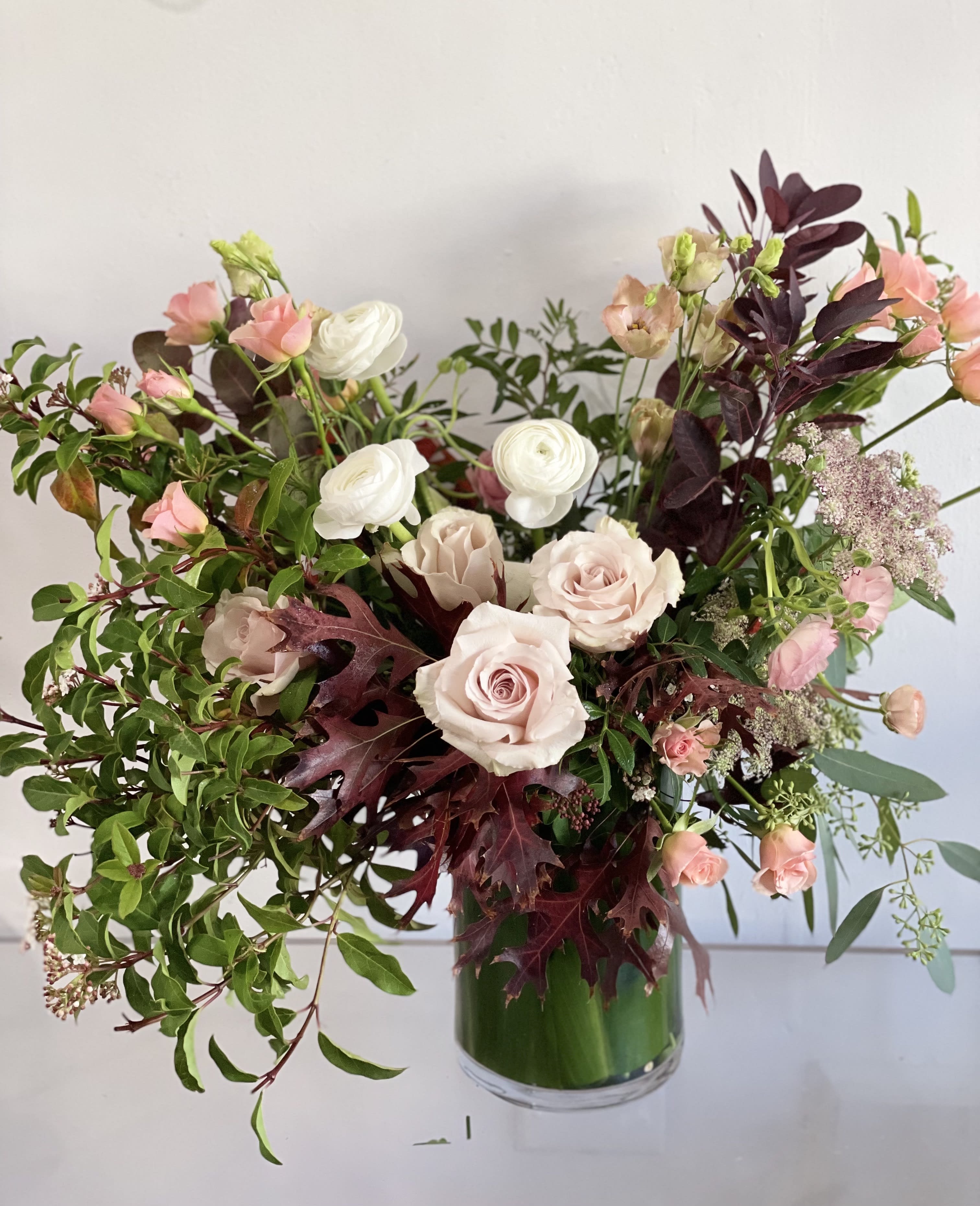 Peachy for Fall  - This beautiful tall arrangement features flowing fall foliage, dusty pink roses, ranunuclus,  chocolate lace, and garden spray roses.  We will select the best of the season if something is not available due to seasonality. If any design element such as color or flower/foliage are very important to your order please contact us to ensure availability first by calling the shop at  415 751 2747   DELUXE are our medium arrangements with more flowers.  Premium are larger arrangements with premium blooms.   Please email us with any questions you may have to info @ fleurt style com   