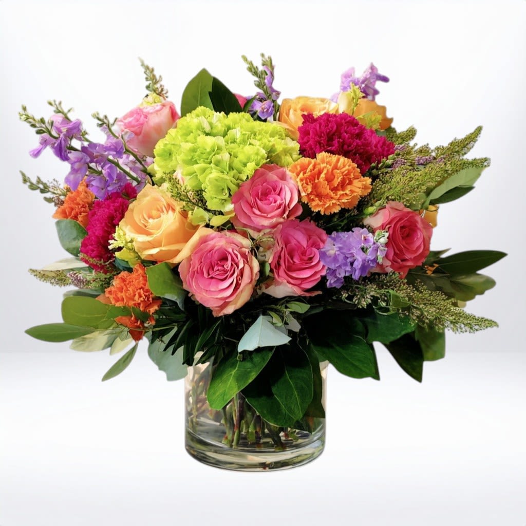 Vibrant Triumph Vibrant Triumph - Celebrate life’s biggest wins with Vibrant Triumph — a bold and joyful floral arrangement bursting with color, texture, and excitement. Featuring a radiant mix of coral carnations, tangerine lilies, golden yarrow, peach and hot pink roses, vivid stock, and lush green hydrangea, this bouquet is designed to uplift and impress. Hand-arranged in a clear glass vase and accented with fresh eucalyptus and rich greenery, this celebratory design is perfect for sending congratulations for a new job, promotion, graduation, engagement, or any milestone worth cheering for. Whether you're sending flowers to say "You did it!" or just want to share the moment, Vibrant Triumph delivers your message with style and impact. Available for same-day delivery in: Houston, Galveston, League City, Friendswood, Dickinson, Alvin, and surrounding Texas Gulf Coast communities.