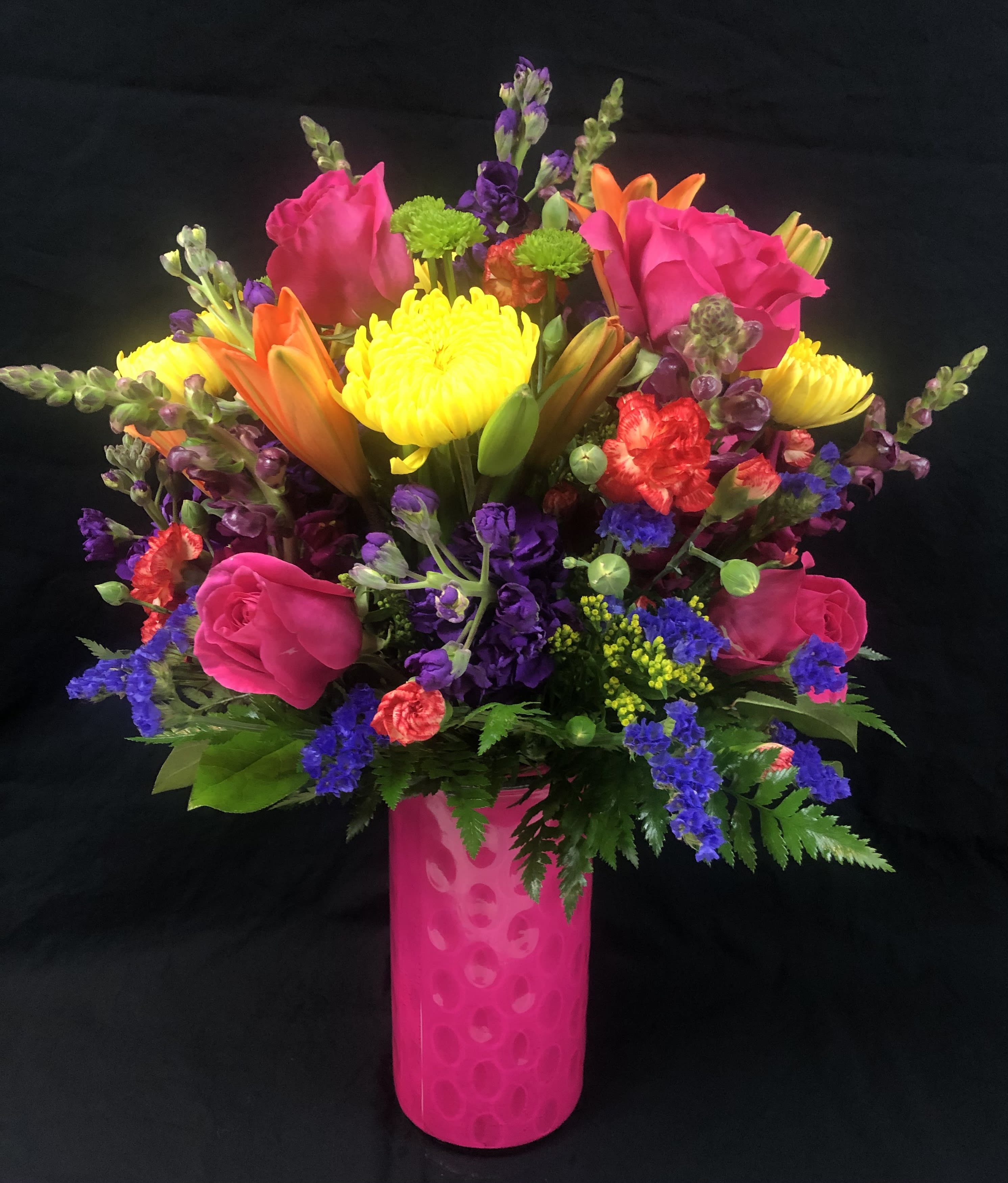 Make A Wish (pide un deseo) - IMAGE ON DISPLAY  IS A PREMIUM DESIGN.    Colorful and vibrant flowers display.  Color vase including Lily’s, Roses, liatris, stock, hypericum, mini carnations, poms, and greens.