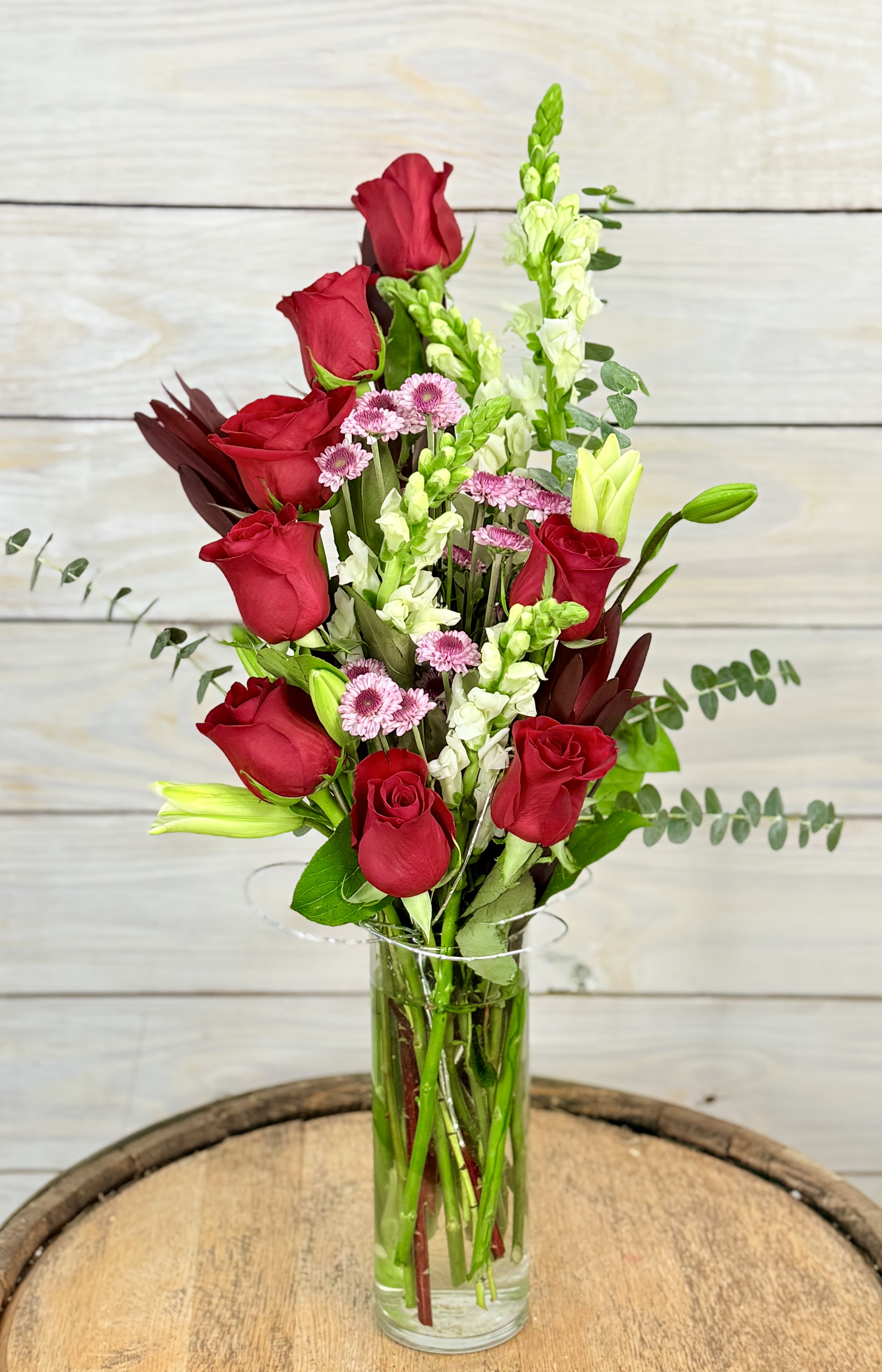 Crimson Crush - Ignite the flames of your love with this red rose arrangement. A tall glass vase cradles a breathtaking medley of romance and elegance. This arrangement doesn't just say &quot;I love you&quot; - it declares it with depth, drama and devotion. A perfect symphony of the heart.
