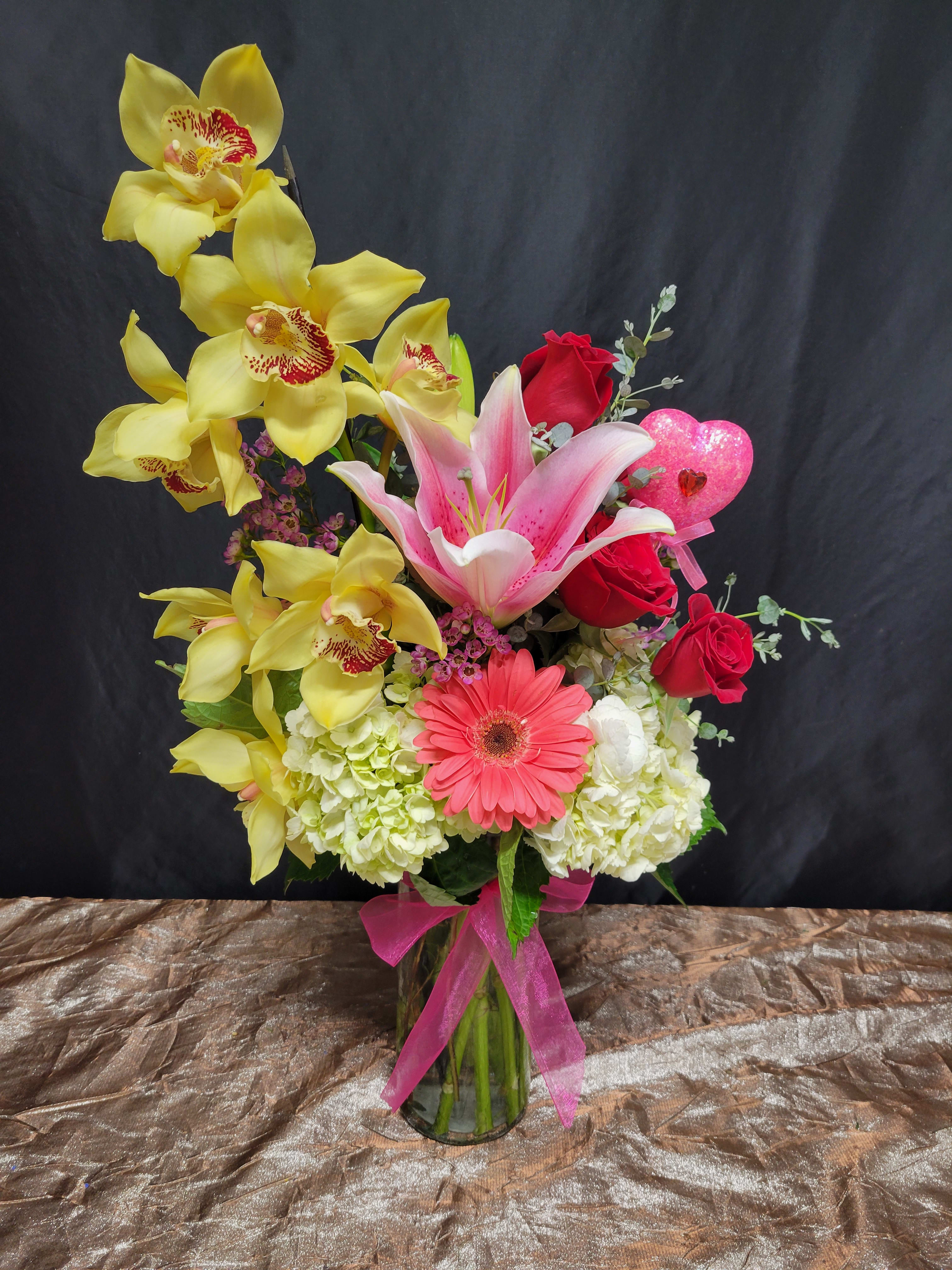 Blushing in Love Blushing in Love - Lilies, lisianthus, roses, oh my! With a vibrant mix of flowers and colors, this arrangement is a great way to create a happy atmosphere for any occasion!
