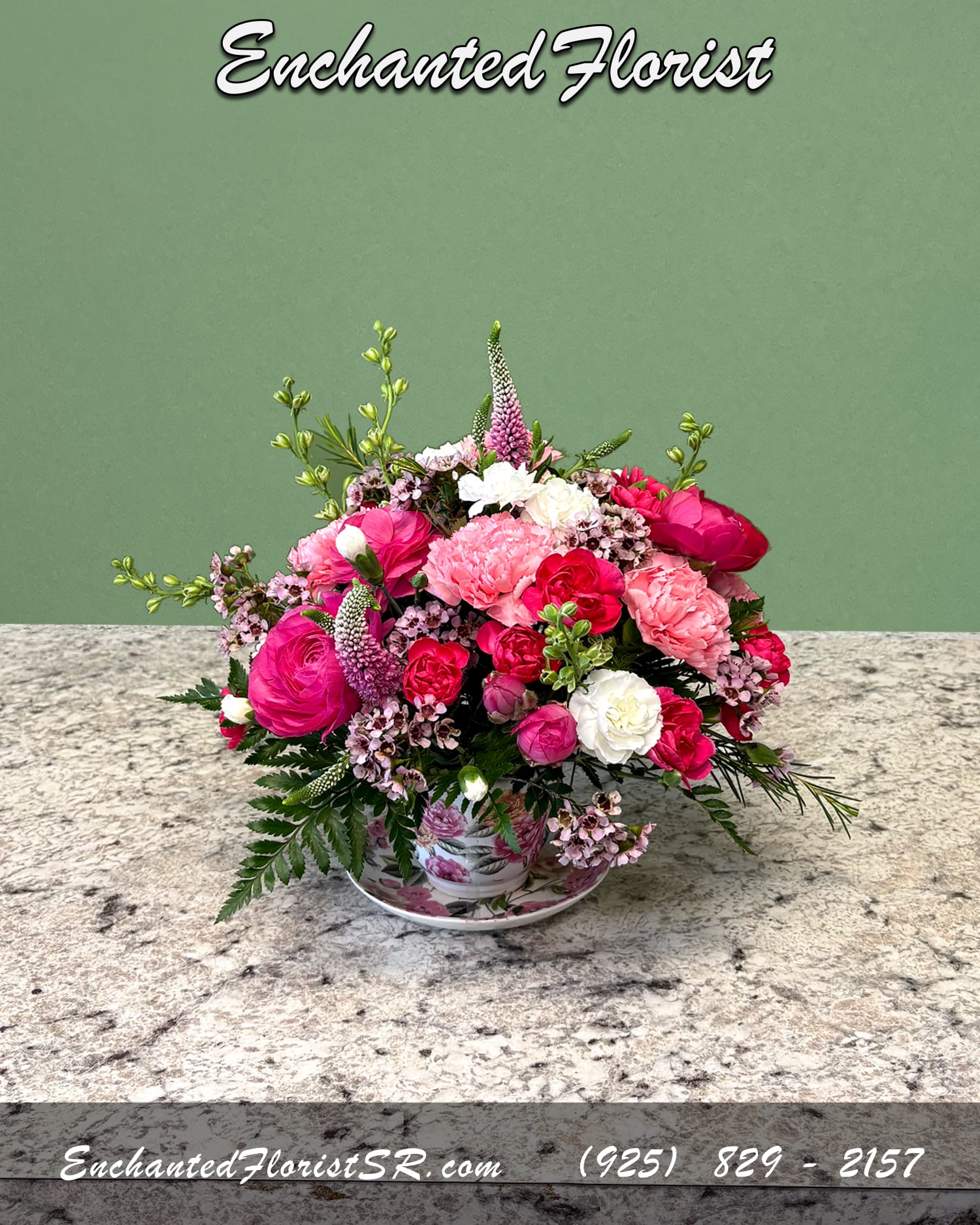 Summer Saucer - Seasonal Arrangement - A charming seasonal arrangement presented in a keepsake teacup and saucer. Featuring a vibrant mix of hot pink ranunculus, veronica, carnations, and larkspur. Accented with wax flower and freshly-cut greens for a playful garden-inspired look.  Perfect for gifting a little joy or adding a whimsical touch to any space.  Arrives In: Ceramic teacup with matching saucer  Orientation: Any-Sided  Approximate Dimensions: 7&quot; Tall 6&quot; Wide 4.5&quot; Saucer Diameter
