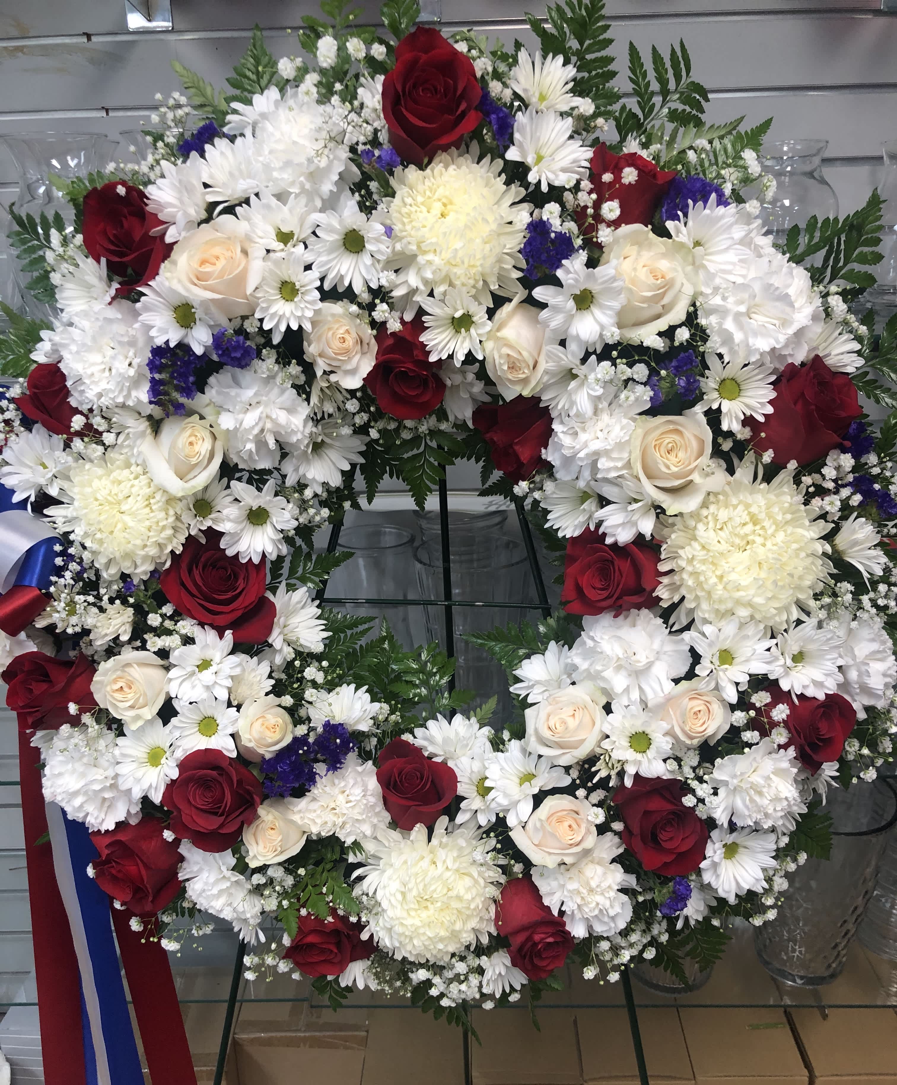 Reverent Roses Wreath Reverent Roses Wreath - The "Reverent Roses Wreath" combines daisies, light pink and white roses, baby's breath, chrysanthemums, and leather leaf for a soft and respectful homage.
