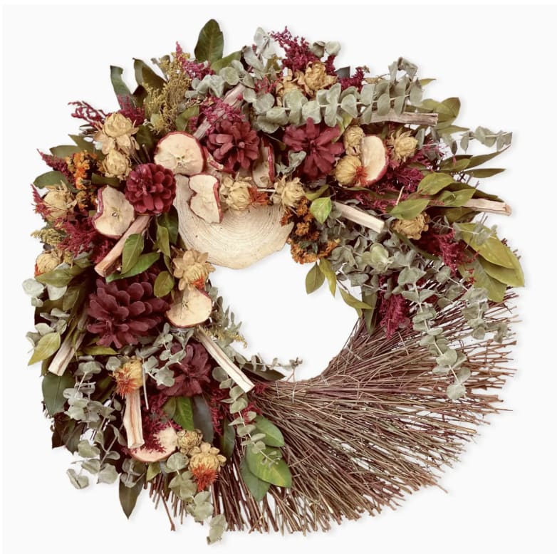 Apple Orchard Wreath - Inspired by ripe apple orchard's in the fall, we designed this handmade wreath using dried apple slices, dried safflowers, eucalyptus and more. Keeping a portion of the twig wreath base exposed really adds to the natural look and feel of the wreath.  - Please note that our wreaths are handmade of natural materials that can be damaged if exposed to rain, snow, or heavy wind. We recommend keeping our wreaths inside or on a covered  porch to protect the wreath.   - 18&quot; diameter - Made using natural florals and materials - Each wreath comes inside a wooden crate  Weight: 5 lb (2.27 kg)  Dimensions: 18 x 18 x 3.5 in (45.7 x 45.7 x 8.9 cm)