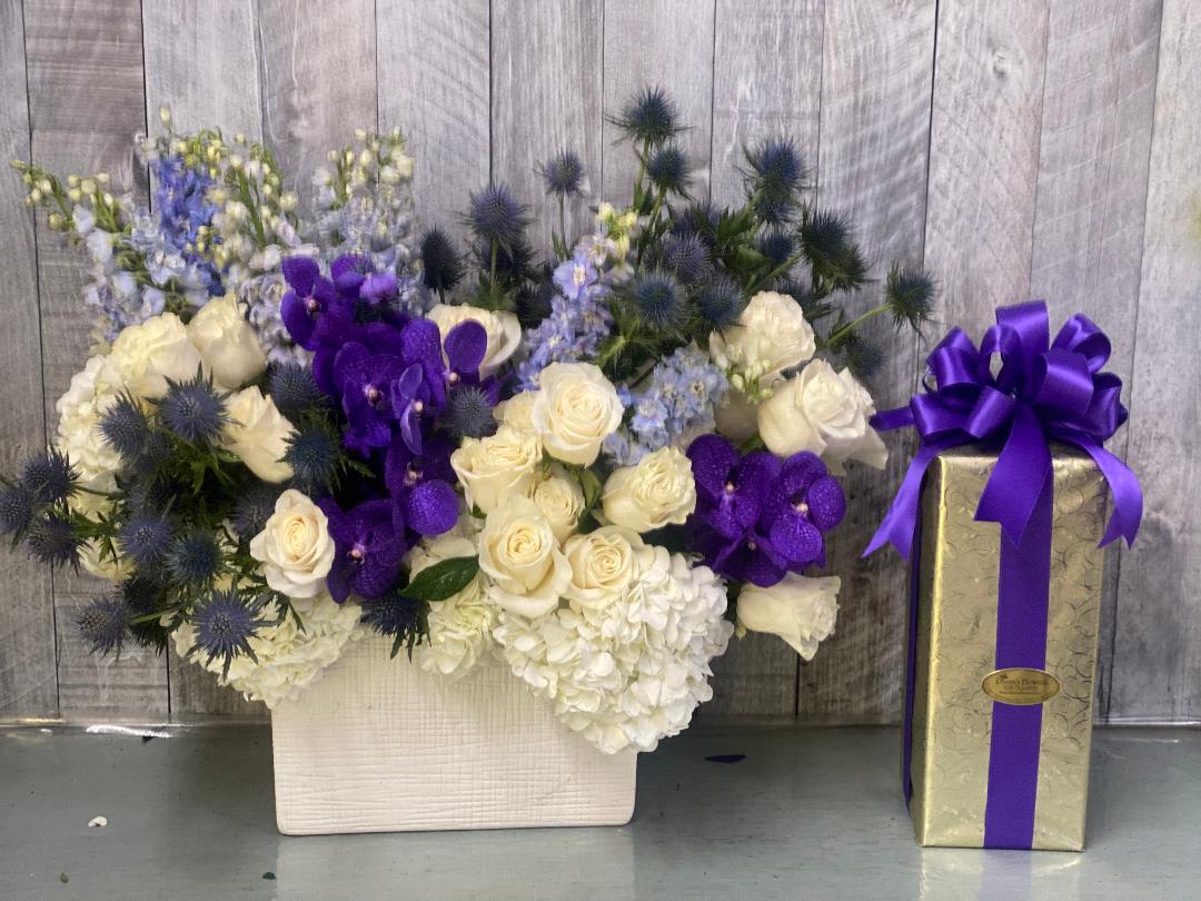 Blue and Purple Sensation Blue and Purple Sensation - Add a refreshing touch with this captivating blue and purple flower arrangement, designed with exotic purple Vanda orchids, striking eryngium, and vibrant blue delphinium. Soft white roses and lush hydrangea complete the look, creating a modern and elegant bouquet. Perfect for weddings, anniversaries, celebrations, or as a Mother's Day gift, this unique arrangement is sure to leave a lasting impression. the gift box is not included.