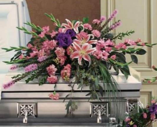 CASKET SPRAY IN PURPLES CASKET SPRAY IN PURPLES - MIXED SHADES OF PURPLE AND LAVENDER FOR THE THE CASKET