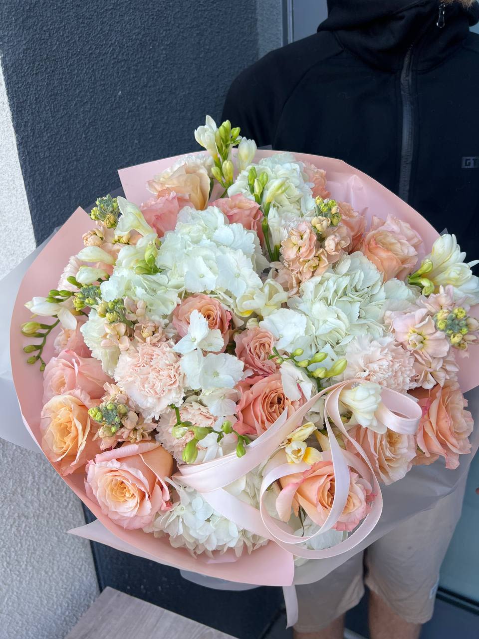 Blush Bloom Blush Bloom - Blush Bloom is a delicate and elegant composition that captures the softness of a quiet sunrise. Featuring peach roses, fragrant stock (matthiola), fluffy white hydrangeas, graceful freesias, and ruffled carnations, this bouquet blends creamy and blush tones to create a warm, romantic atmosphere. Perfect for heartfelt moments, gentle celebrations, or simply saying “I care.”