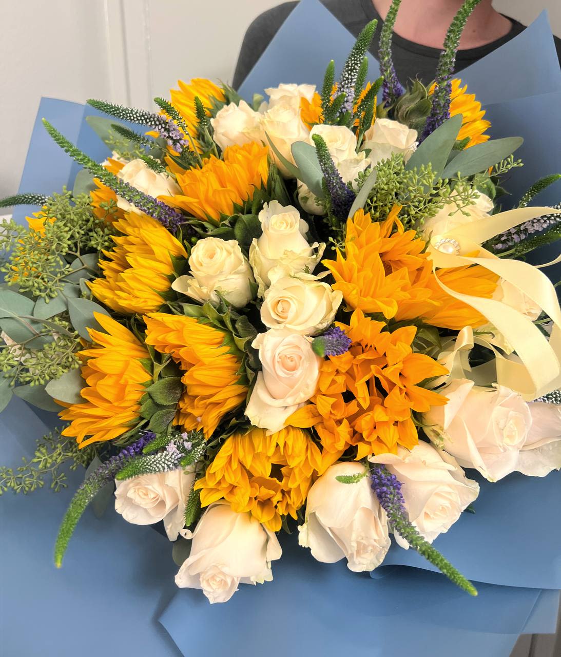 Sun-Kissed Bliss - Sun-Kissed Bliss   A touch of sunshine captured in every petal. This bouquet blends the softness of cream roses with the radiant glow of golden sunflowers, creating a warm, joyful, and cozy atmosphere. The perfect choice to bring a smile and brighten someone’s day!   Perfect for:  Expressing gratitude  Creating a warm ambiance  Celebrating special moments  Let Sun-Kissed Bliss bring a little sunshine and happiness to your loved ones! 