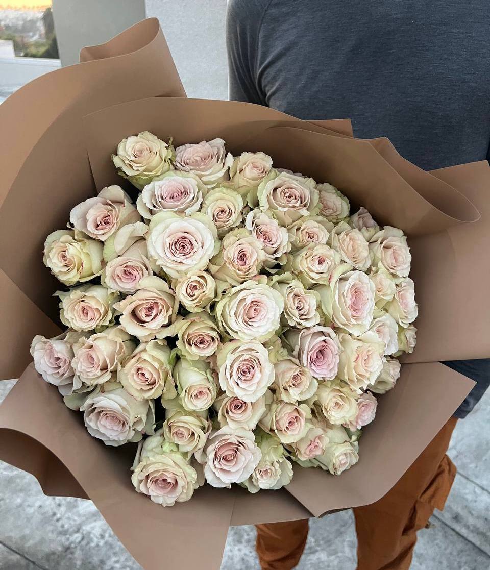 50 Creamy  roses - A delicate and elegant bouquet of 50 cream-colored roses, exuding timeless sophistication and romance. Each rose is carefully selected for its soft pastel hue, with petals gently transitioning from a warm ivory to a blush pink at the center. Wrapped in earthy-toned paper, this arrangement creates a sense of refined charm and natural beauty. Perfect for expressing love, admiration, or gratitude, this bouquet is a graceful gift for any special occasion.