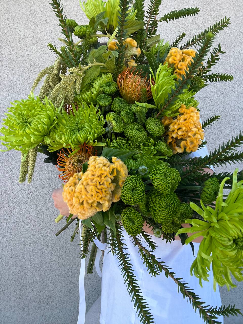 Raw &amp; Radiant - “Raw &amp; Radiant” is a bouquet that merges untamed natural energy with a vibrant freshness. Lush green foliage interweaves with bright yellow blooms, creating the impression of a wild yet harmonious oasis. It’s the perfect choice for those who appreciate nature’s beauty and wish to bring a touch of raw, living magic into their space.
