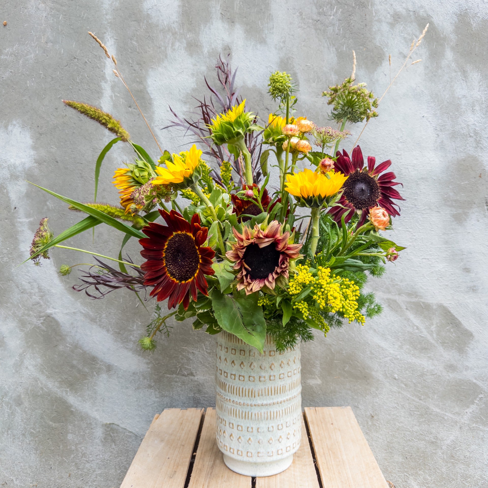 The Van Gogh - Getting inspiration from Van Gogh's sunflower portraits, this arrangement is our modern interpretation with local sunflowers and other complimenting flowers in a ceramic container. Upgrade to deluxe or premium for additional premium blooms.  Standard size measures approximately 24'' by 12''. 