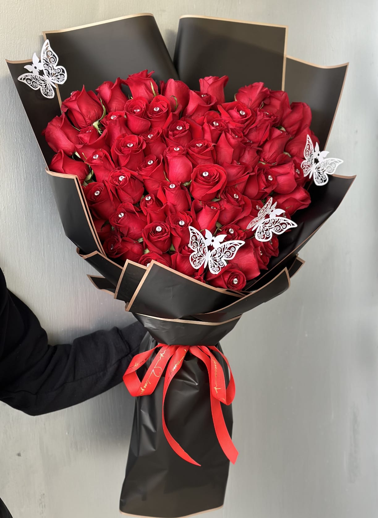Pretty in RED  - One side rose bouquet with crystal stones wrapped beautifully with water proof paper and red bow 37 roses and diamond pins with 3 beautiful white butterflies 