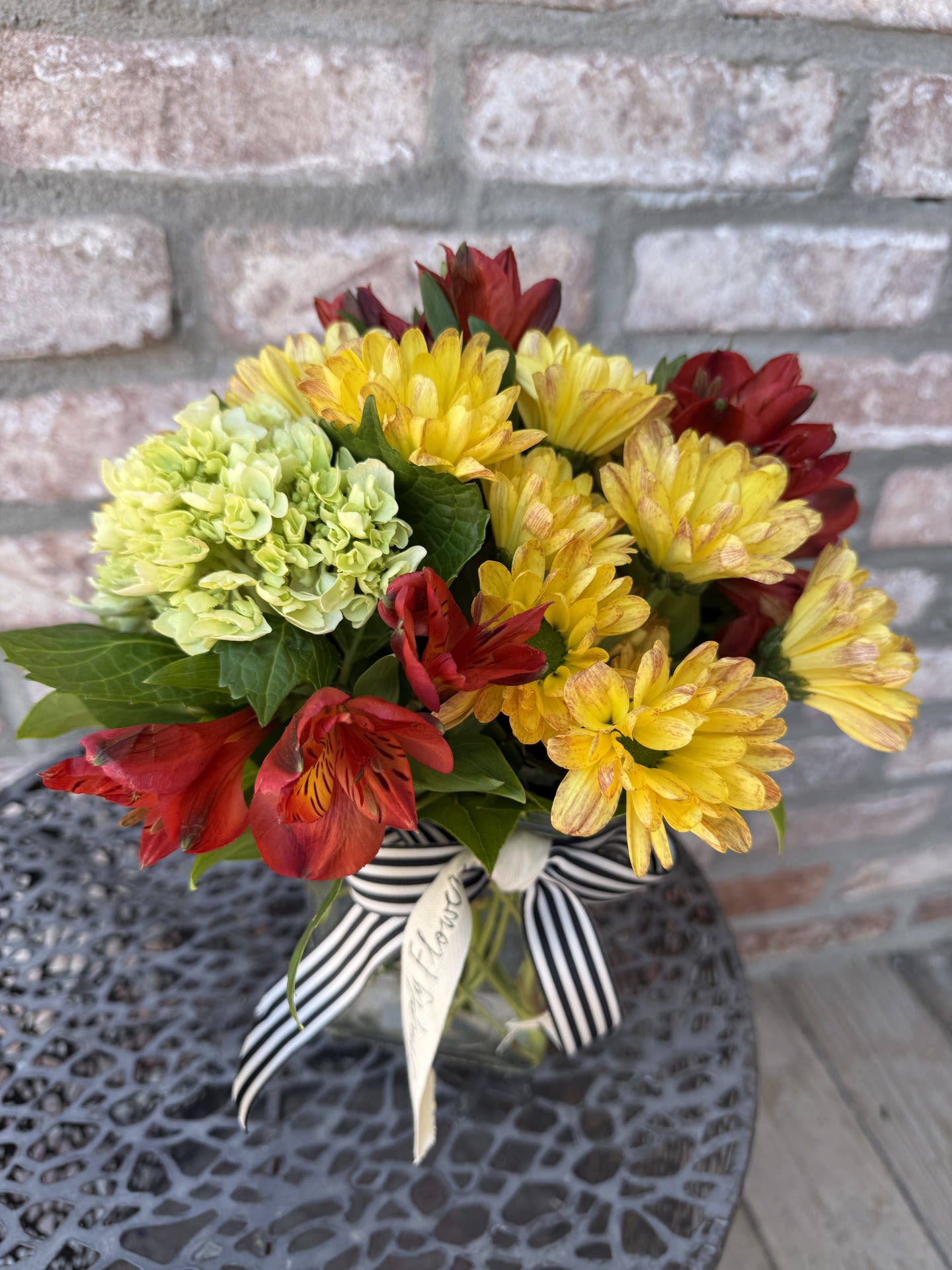 New! Autumn Welcome New! Autumn Welcome - Welcome Autumn with this bountiful beauty. Designed in a rectangular glass vase. Filled with long lasting alstromeria, daisy poms and green hydrangea. Measures approximately 12" tall.