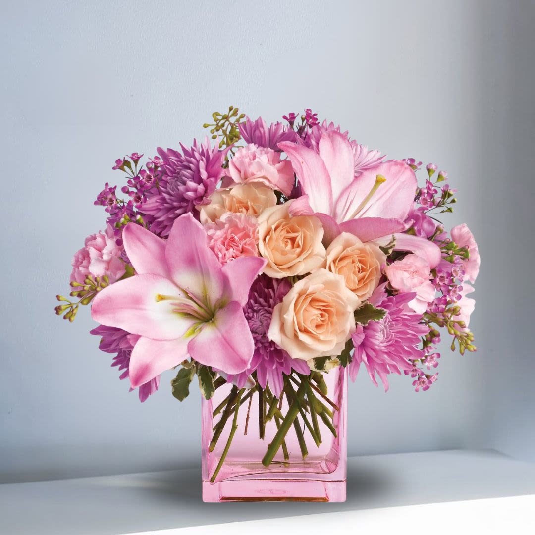 Sweetness and Laughter Sweetness and Laughter - This arrangement is absolute delightful and will put a smile on someone's face! Recipe: Asiatic Lillies, Roses, Carnations, and Chrysanthemum in a pink square, 5x5 vase. Availability: All year round Design View: All Facing View Photo shown: Standard