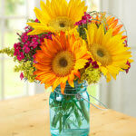 Gold Crush  - Gold Crush is filled with inspirational colors and is perfect for the one who loves sunflowers. Gold Crush will certainly chase the blues away and brighten his or her day.  Note: Depending on order timing, the Blue vase may be substituted with a clear vase. Sunflower colors also vary depending on the options available at the time of your order. 