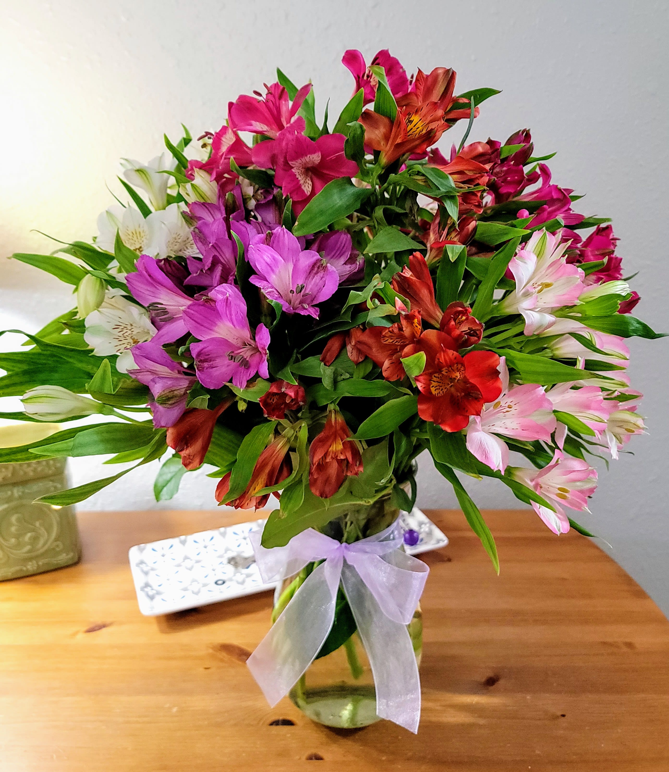 Rainbow Peruvian Lily Bouquet - A kaleidoscope of intense color can best describe this vivid arrangement boasting alstroemeria in yellow, purple, orange, red and hot pink in a clear vase with a pretty ribbon bow. Measures 16&quot;H by 14&quot;L.