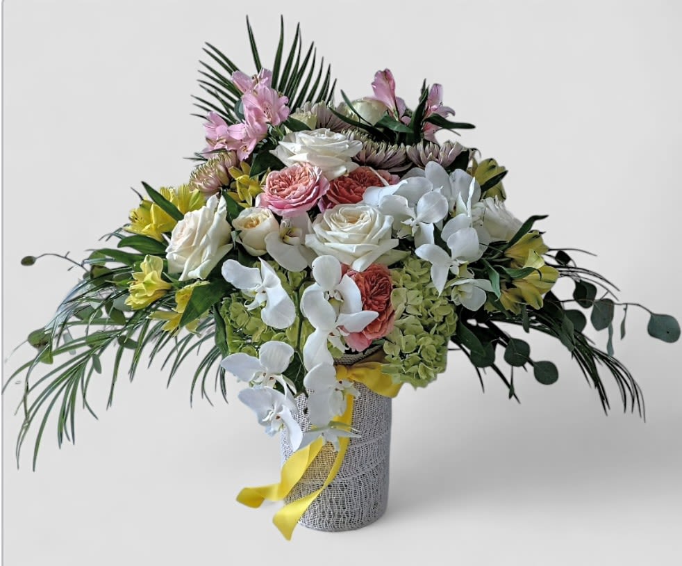 With Our Deepest Sympathy Bouquet Designer's Choice - Beautiful and filled with hydrangea orchids roses and more arranged in a tall modern glass cylinder vase wrapped in white jute ribbon. Perfect to send today to show them how much you care. Always made extra special and unique each time. Send them your deepest condolences.