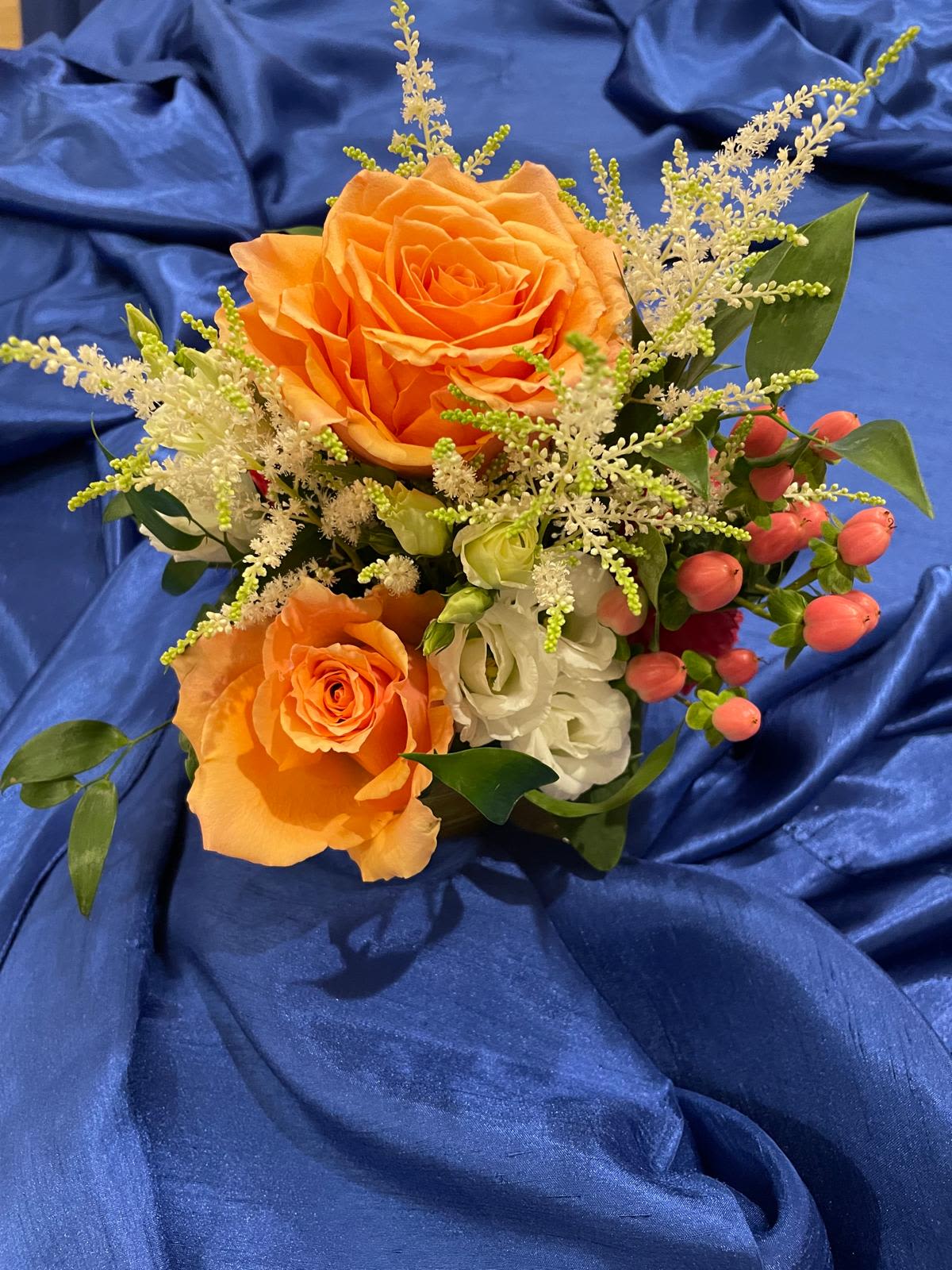 Sunset Glow Sunset Glow - A delicate and radiant arrangement featuring vibrant orange roses, creamy lisianthus and charming pink hypericum berries. Set against lush greenery, this design brings warmth, freshness, and a joyful touch to any occasion — like capturing the beauty of a glowing sunset in bloom