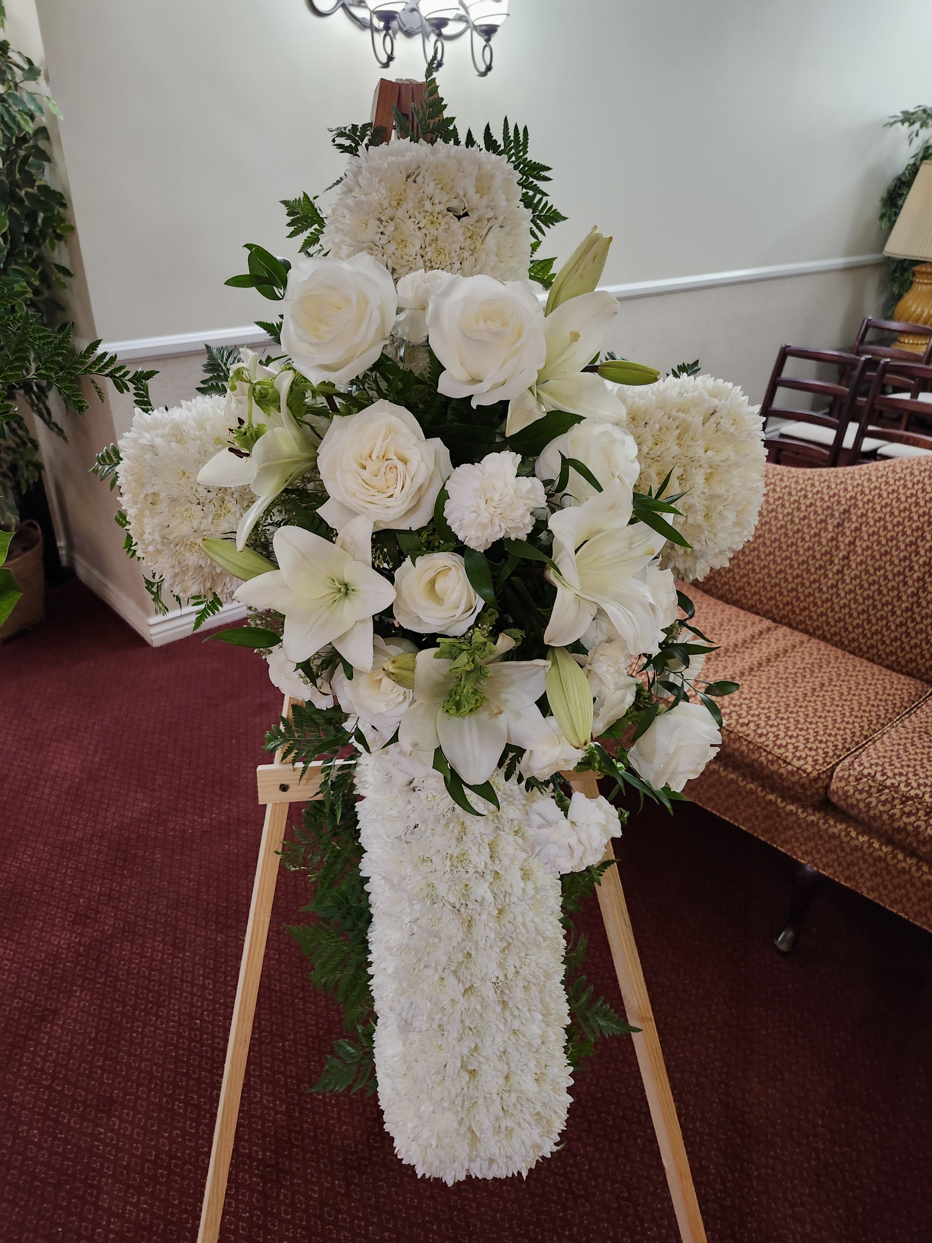 Sympathy White Cross Sympathy White Cross - All white cross with cushion mums, roses, Lillie's, carnacarnations. Shown in medium size 3-4ft. in length. For personalized ribbon, search sympathy banner for additional item.