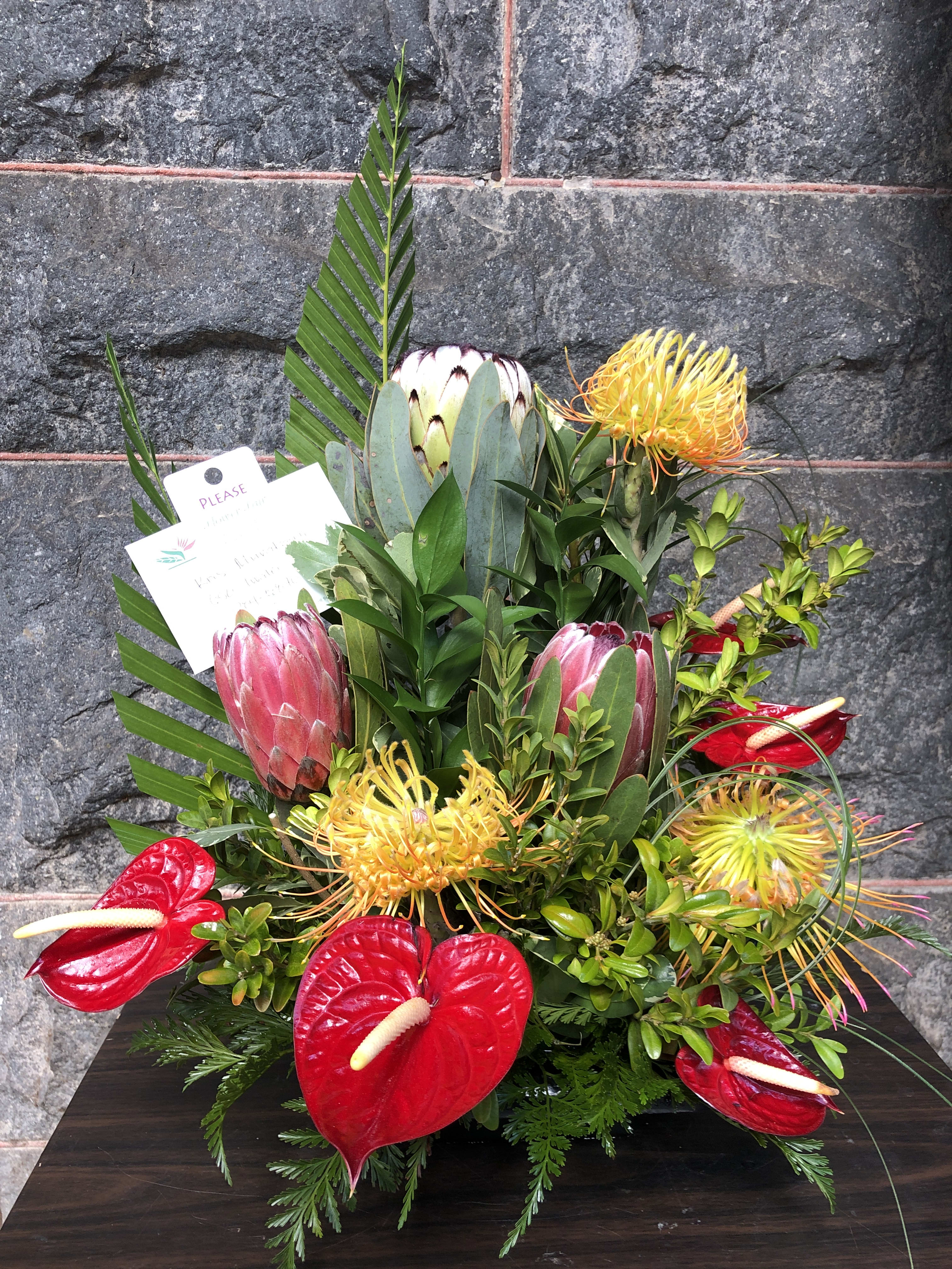 Mid Autumn Fest Trop2101 - Medium Size tropical floral direct from Maui and Big IslandFarm. Mink proteas, Pincushions and anthuriums used in creating this stylized arrangement. Check for seasonal availability. 