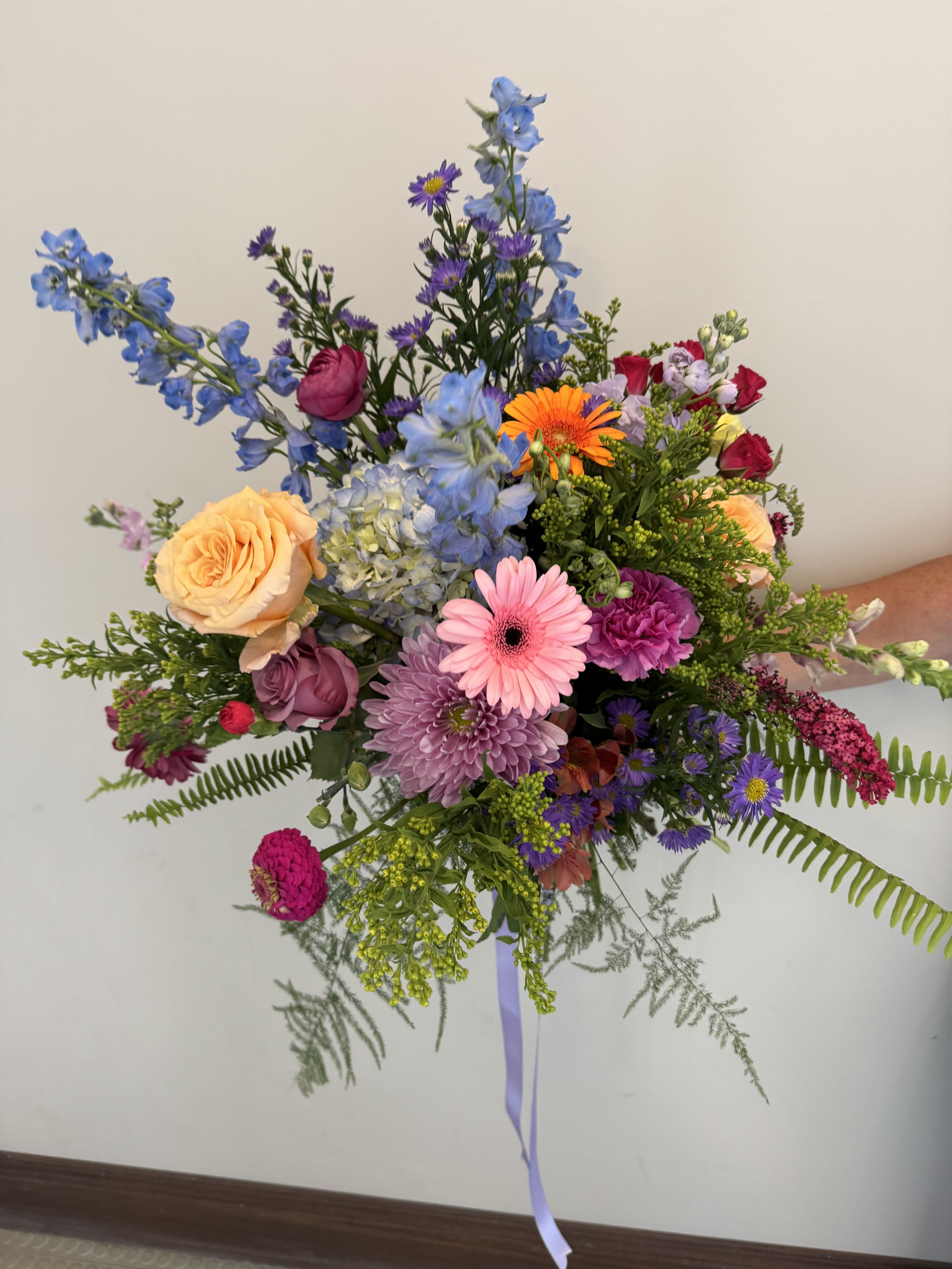 Hand Tied Wildflower Bouquet Hand Tied Wildflower Bouquet - This bouquet comes without a vase or container . it allows you to put it in your favorite vase once it is received. We will assemble the seasons brightest and most beautiful blooms in a clear wrapping .