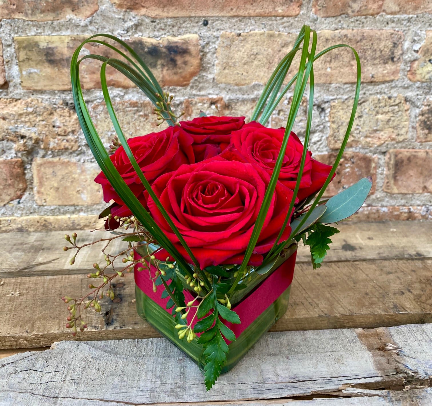 He Loves me - A tight arrangement of roses in a cube with a touch of greens and a bear grass heart hovering above it all. The perfect gift to say &quot;I love you!&quot;. Everyone in the Kenosha area will be green with envy.  We are proud to deliver our flower creations to the Kenosha, Somers, and Pleasant Prairie area. With over 55 years of combined flower design experience in Kenosha, Wisconsin, A Summer's Garden Florist and Gifts is the perfect choice for the freshest flowers, most creative design, and exceptional customer service.