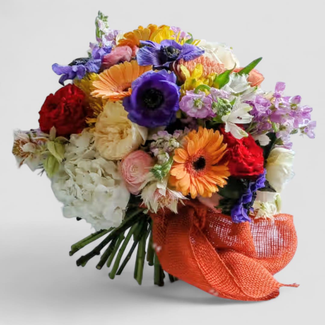 The Beautiful One Colorful Bouquet Designer's Choice - Send this beautiful colorful mixed blossoms of the day bouquet with roses hydrangeas daisies and more wrapped in pretty peach paper with a peach ribbon bow without a vase. Send them happiness.
