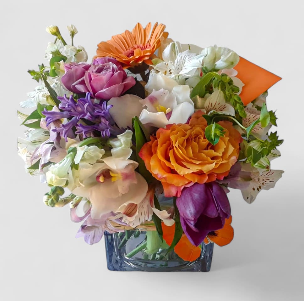 Blush And Violet Bouquet Designer's Choice Blush And Violet Bouquet Designer's Choice - Designer's choice; made beautifully from my blush and violet blossoms of the day roses orchids and more arranged in a modern glass cube vase adorned with a lovely butterfly. Always made extra special and unique each time. Perfect to send today for every reason to make them smile. Send happiness.