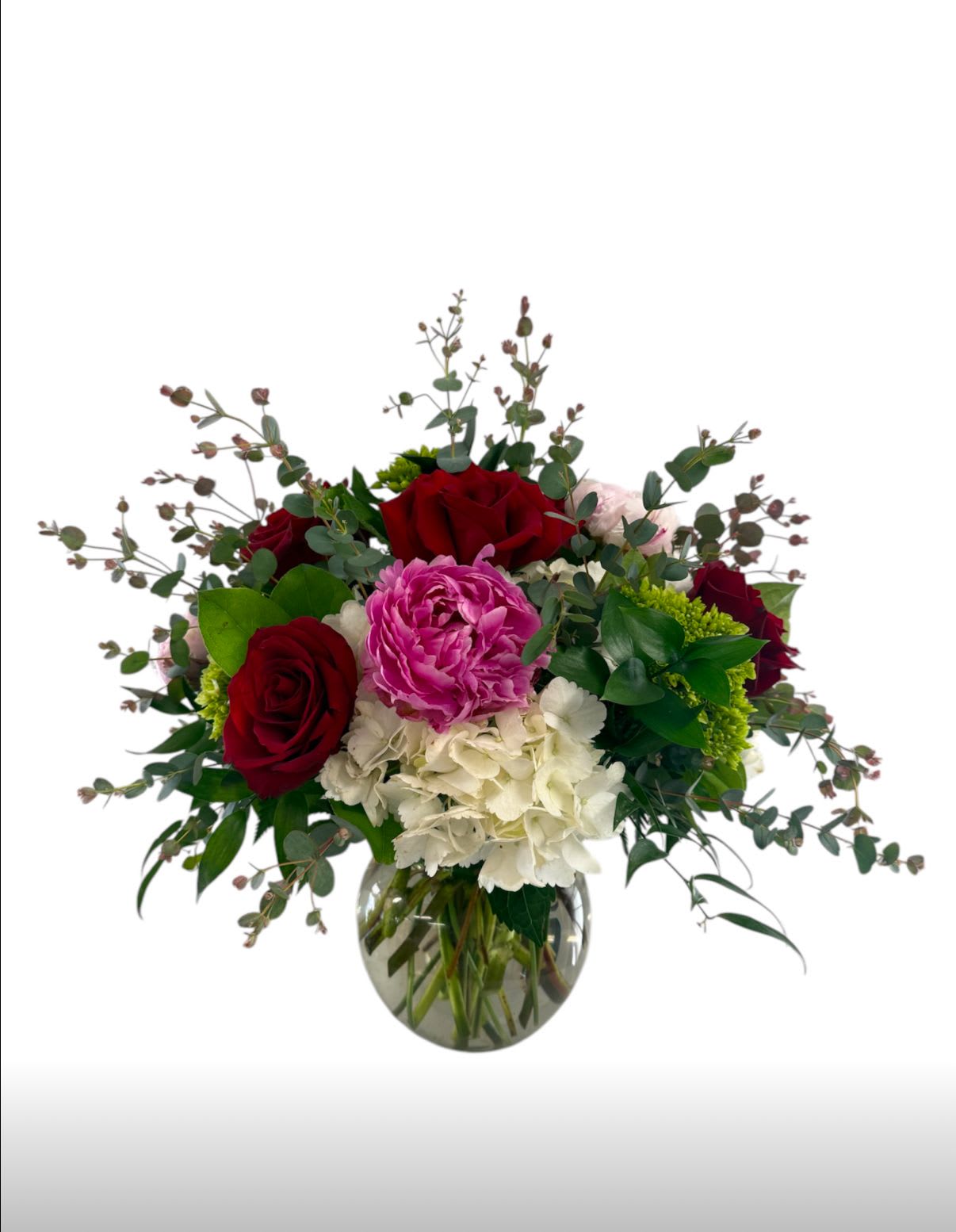 Floral Fantasy - A fragrant mix of roses and peony with white and green hydrangea and eucalyptus design in a clear glass vase.