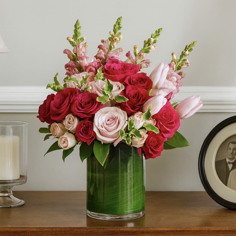 Cherish Bouquet - Our Cherish arrangement is to send someone you care very much for. A combination of pink florals such as roses, spray roses, tulips and snapdragons filled in a clear cylinder vase with green tea leaf. 
