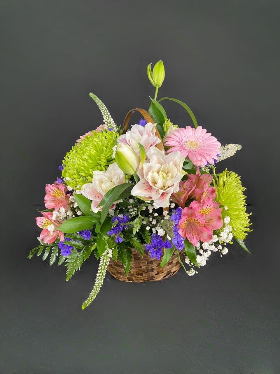 Garden Basket - A delightful basket filled with fragrant flowers including Rose Lilies, Alstroemeria, Gerbera Daisies, Statice, Spider Anastasia, and Babies Breath.