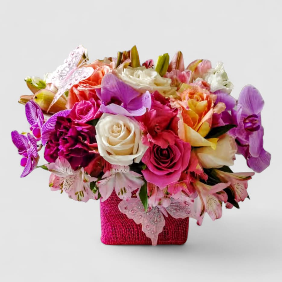 Pink Spectacular Bouquet Designer's Choice - Roses orchids hydrangeas and so much more arranged in a modern glass cube vase wrapped in pretty pink jute ribbon adorned with a lovely butterfly. Beautiful and perfect to send today to show them how much you care. All of my bouquets are always made extra special and unique each time. Send them happiness. Send them beautiful.