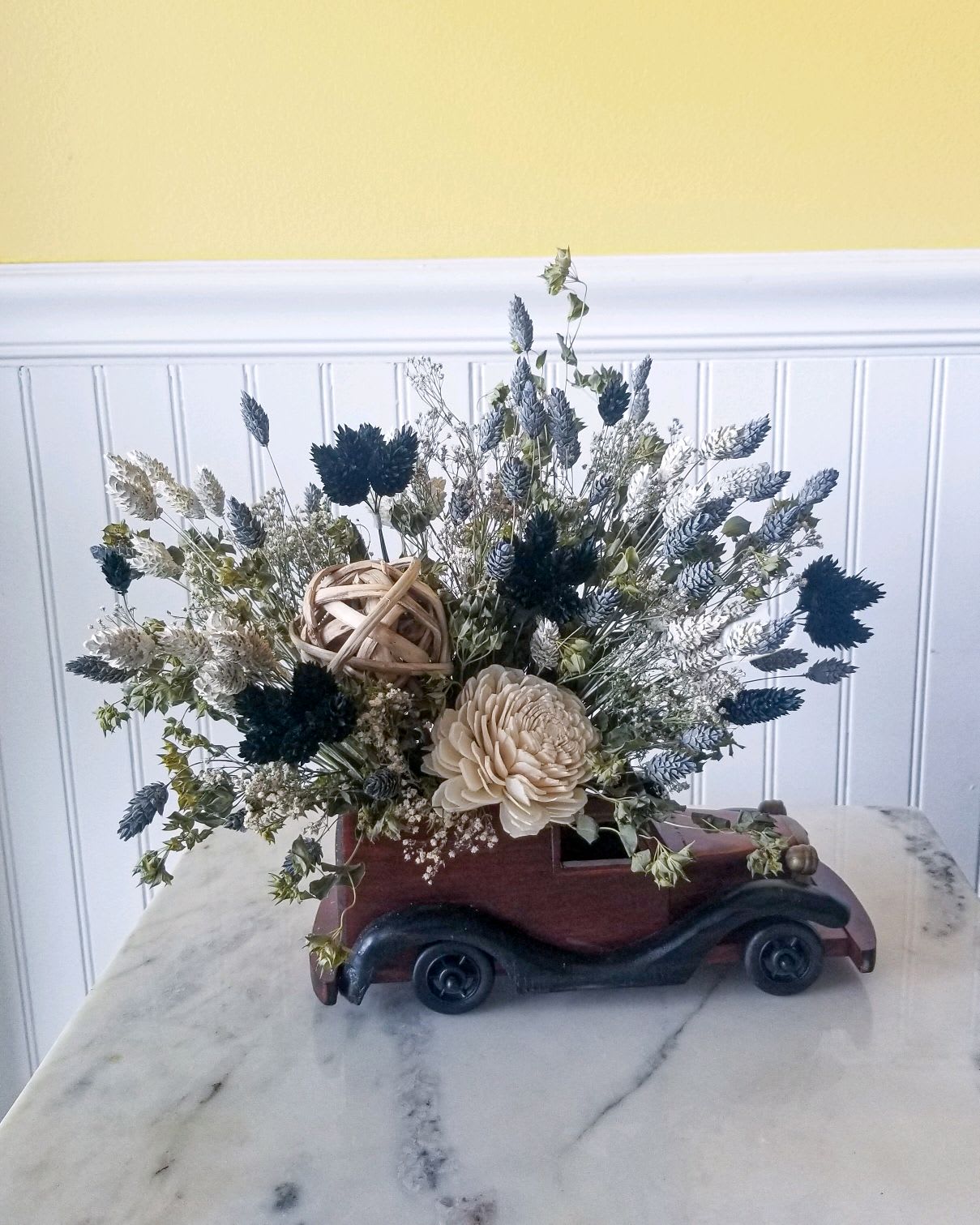 Classic Auto - Get the motor running.  This classic wooden auto will surely be displayed and cherished for years because it's filled with dried florals that will last!  A great gift or conversation piece. H  13&quot;  W: 13&quot;