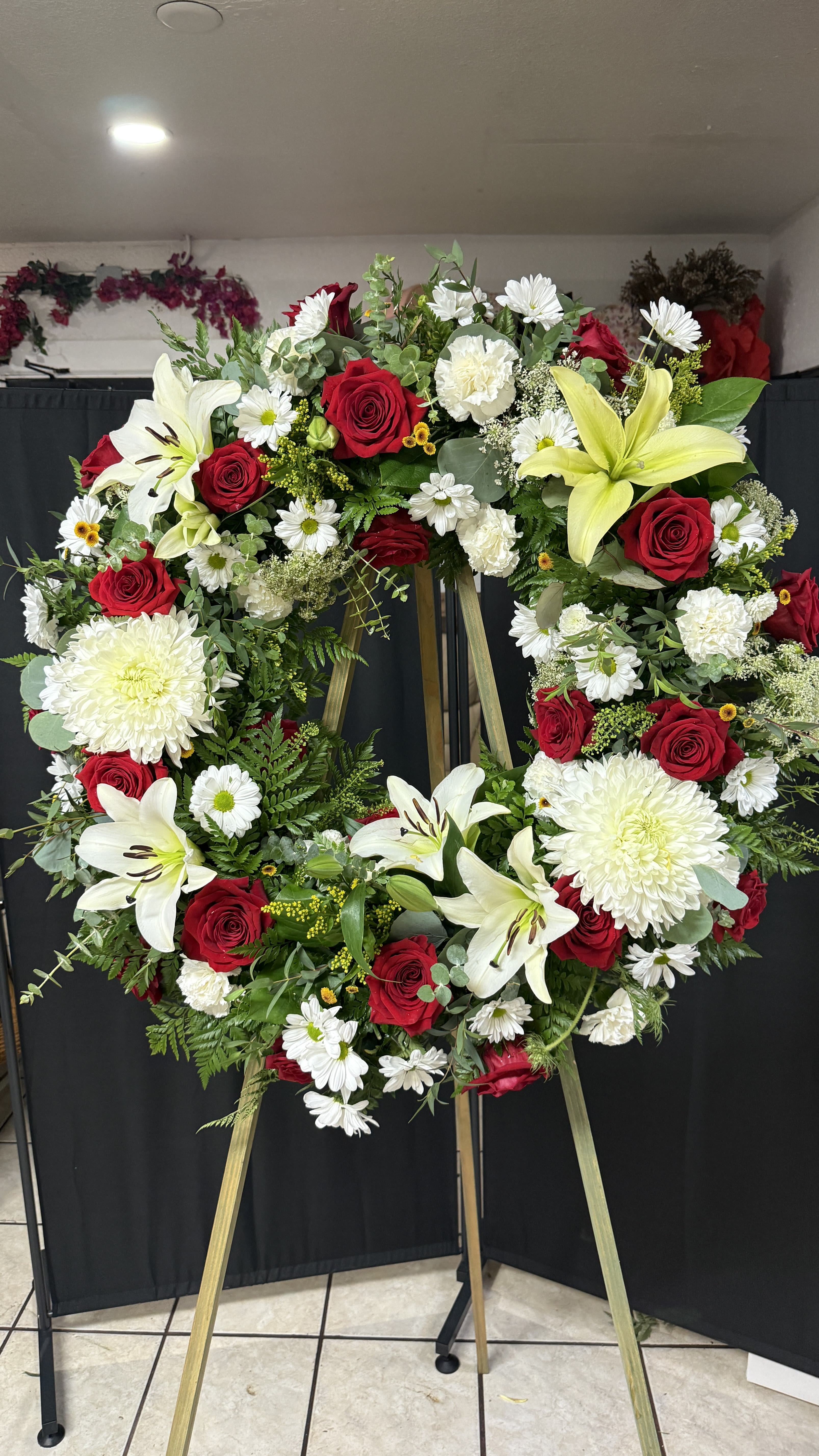 Circle of life Wreath Circle of life Wreath - This elegant sympathy wreath features a harmonious blend of red and white flowers, artfully arranged on a sturdy stand. Designed to convey heartfelt condolences, this floral tribute serves as a poignant expression of love and remembrance during difficult times. The vibrant red blooms symbolize courage and strength, while the pure white flowers represent peace and purity, making it a fitting choice for honoring a cherished life. Perfect for funerals, memorial services, or as a comforting gesture to grieving families, this wreath is a beautiful way to convey your deepest sympathies.