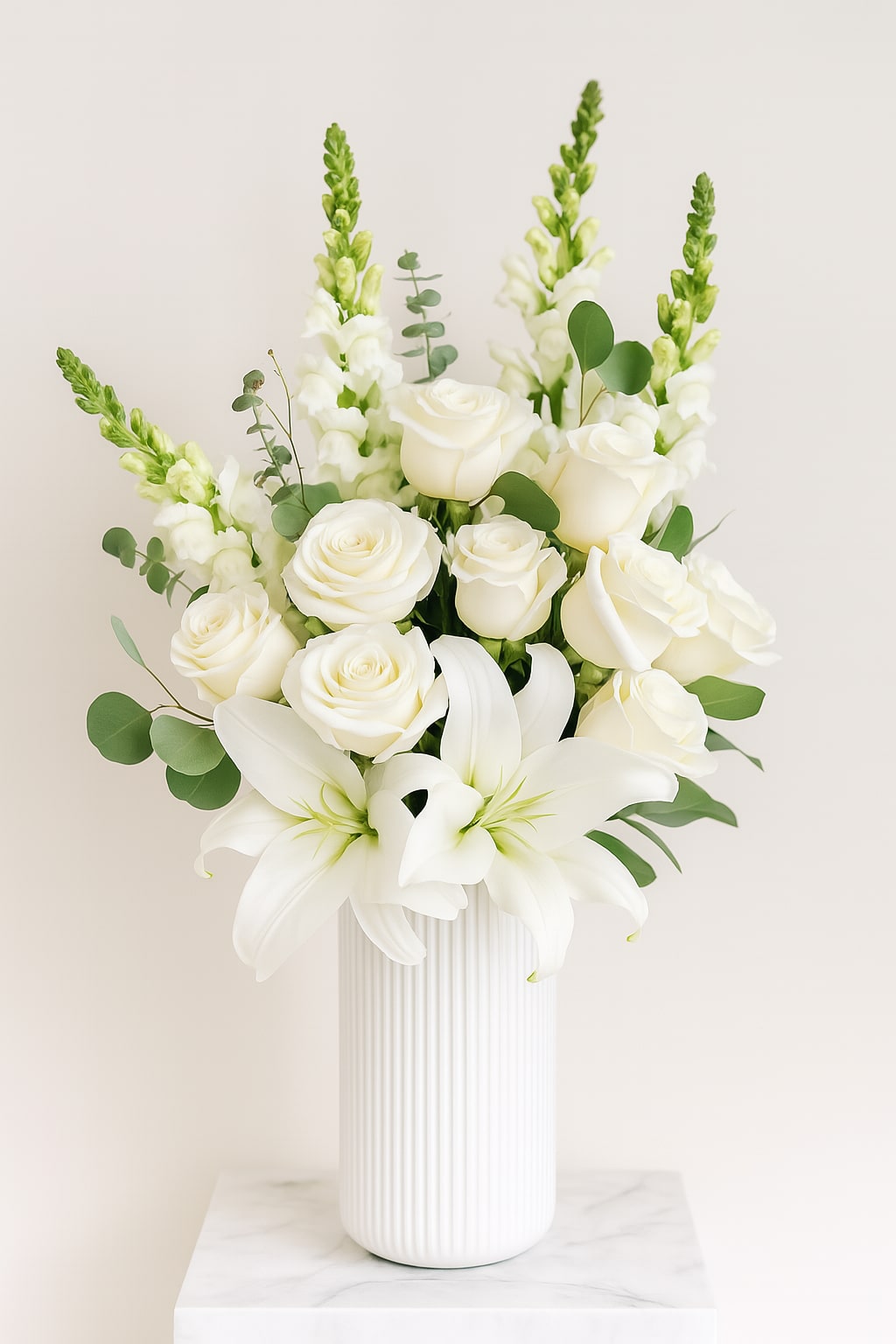 White Serenity White Serenity - A graceful blend of premium white roses, fragrant lilies, and snapdragons, accented with fresh eucalyptus in a modern white ceramic vase. Perfect for sympathy, weddings, or elegant home décor. Clean, classic, and timeless.