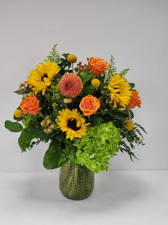 Bountiful Blooms Bountiful Blooms - Bountiful Blooms is a cheerful arrangement bursting with vibrant color and texture. Designed in a clear vase, it features golden sunflowers, bright orange roses, peach dahlias, green hydrangea, and playful accents of crespedia and berries. Full of warmth and charm, this radiant design is perfect for celebrating special occasions or simply bringing joy and brightness into the home.