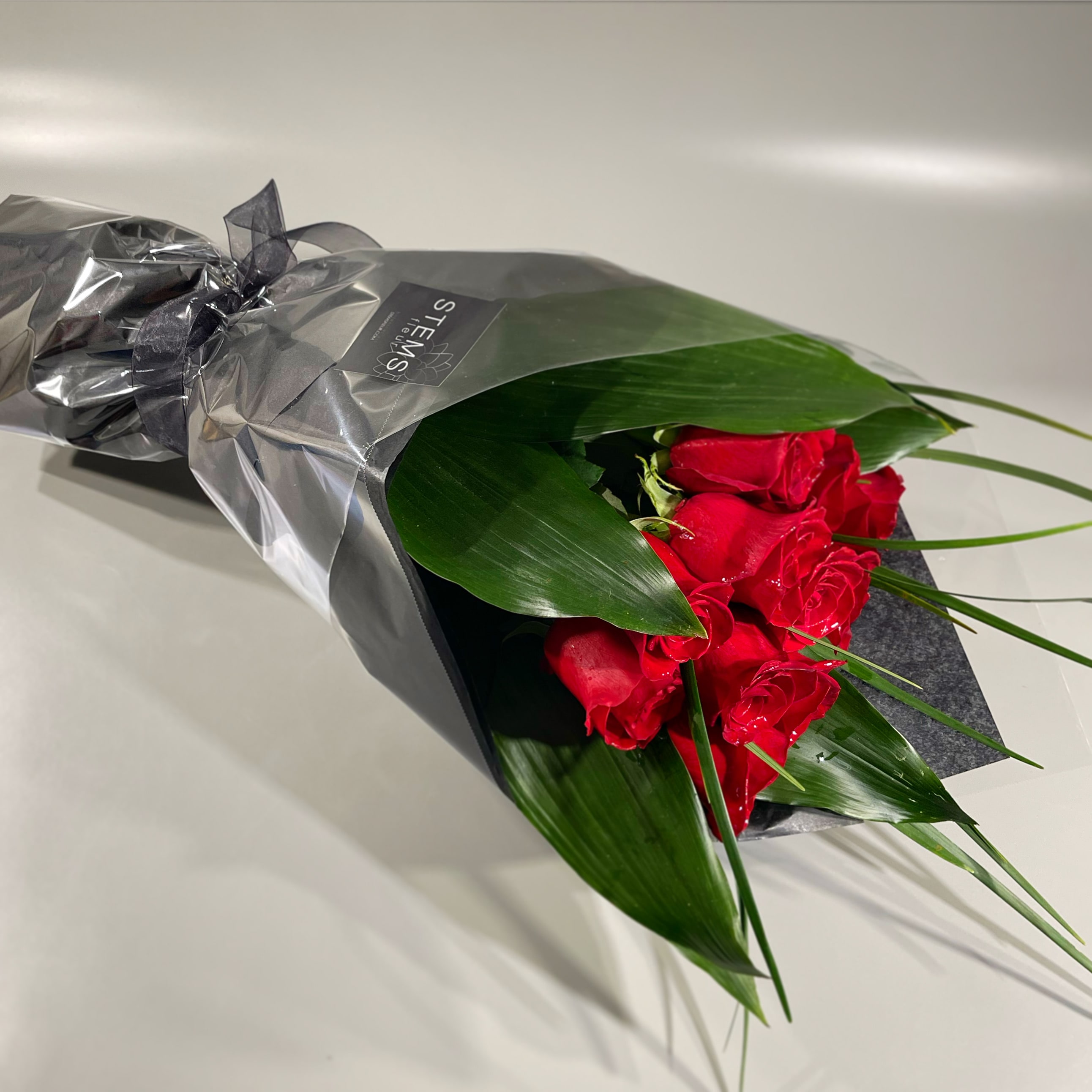 ADORATION - Dozen wrapped roses ADORATION - Dozen wrapped roses - Surprise someone special with a bouquet of wrapped roses which they can arrange in their own vase. *also available in white, pink, or yellow. Please specify color change in the special instructions.