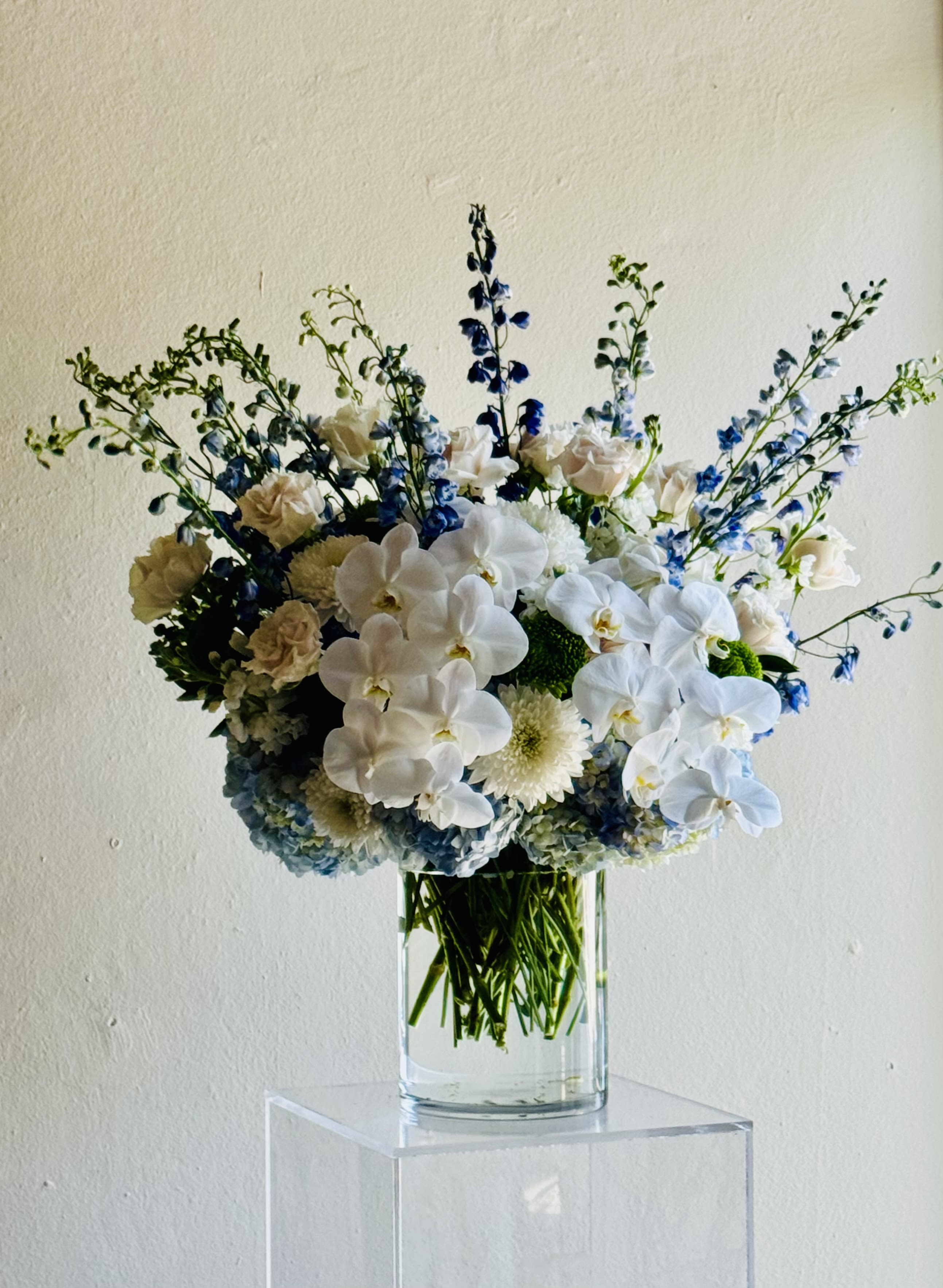 Flora Azure - Whites and blues arranged together in this gorgeous large floral design in a crystal cylinder.  Amazing gift for a baby boy or just to let someone know you are thinking about them. 