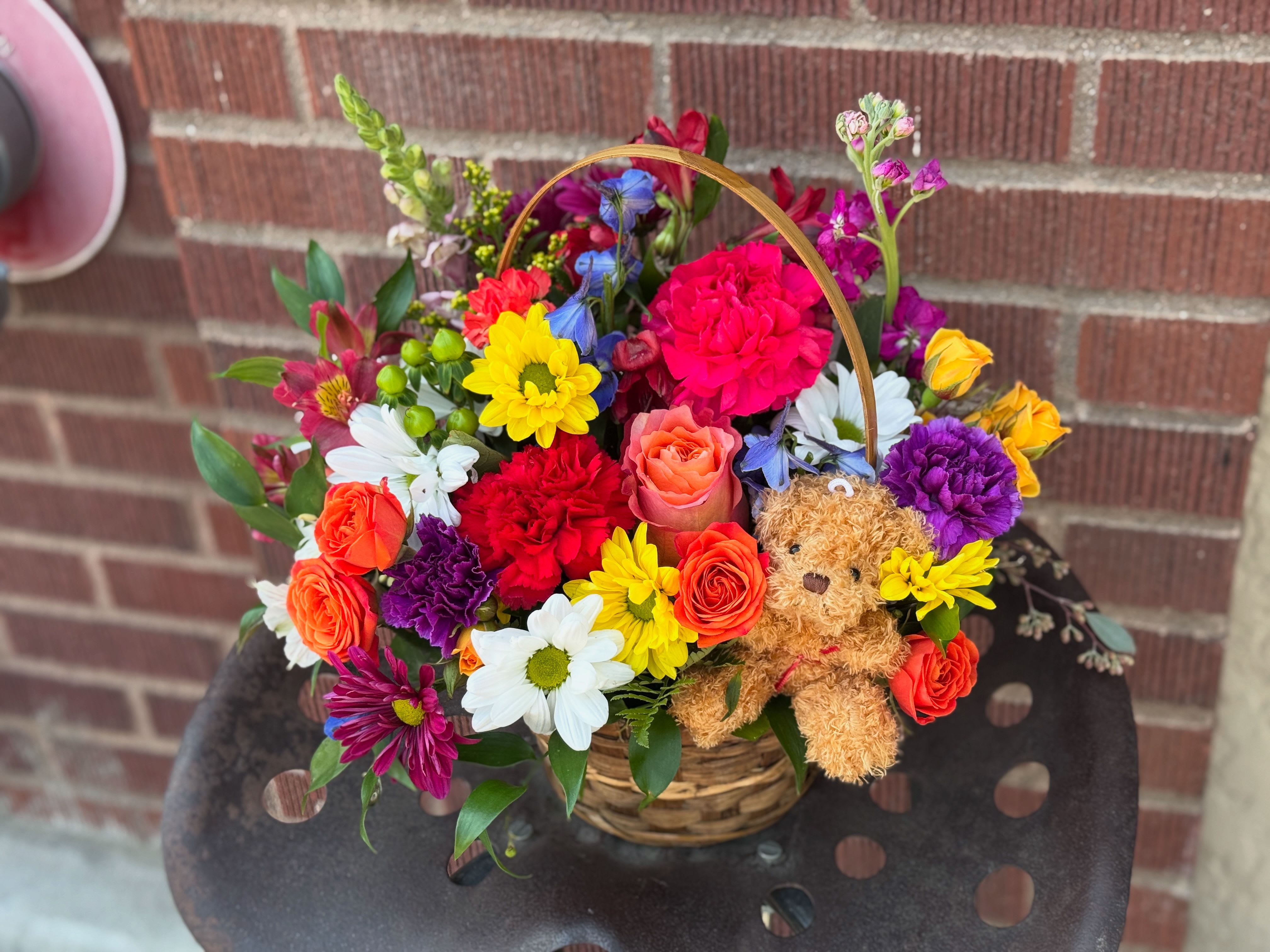 Cute And Fluffy - Bright blooms arrive in a basket with a little fuzzy friend! Bear &amp; arrangement size will iboth ncrease with deluxe and premium options. 