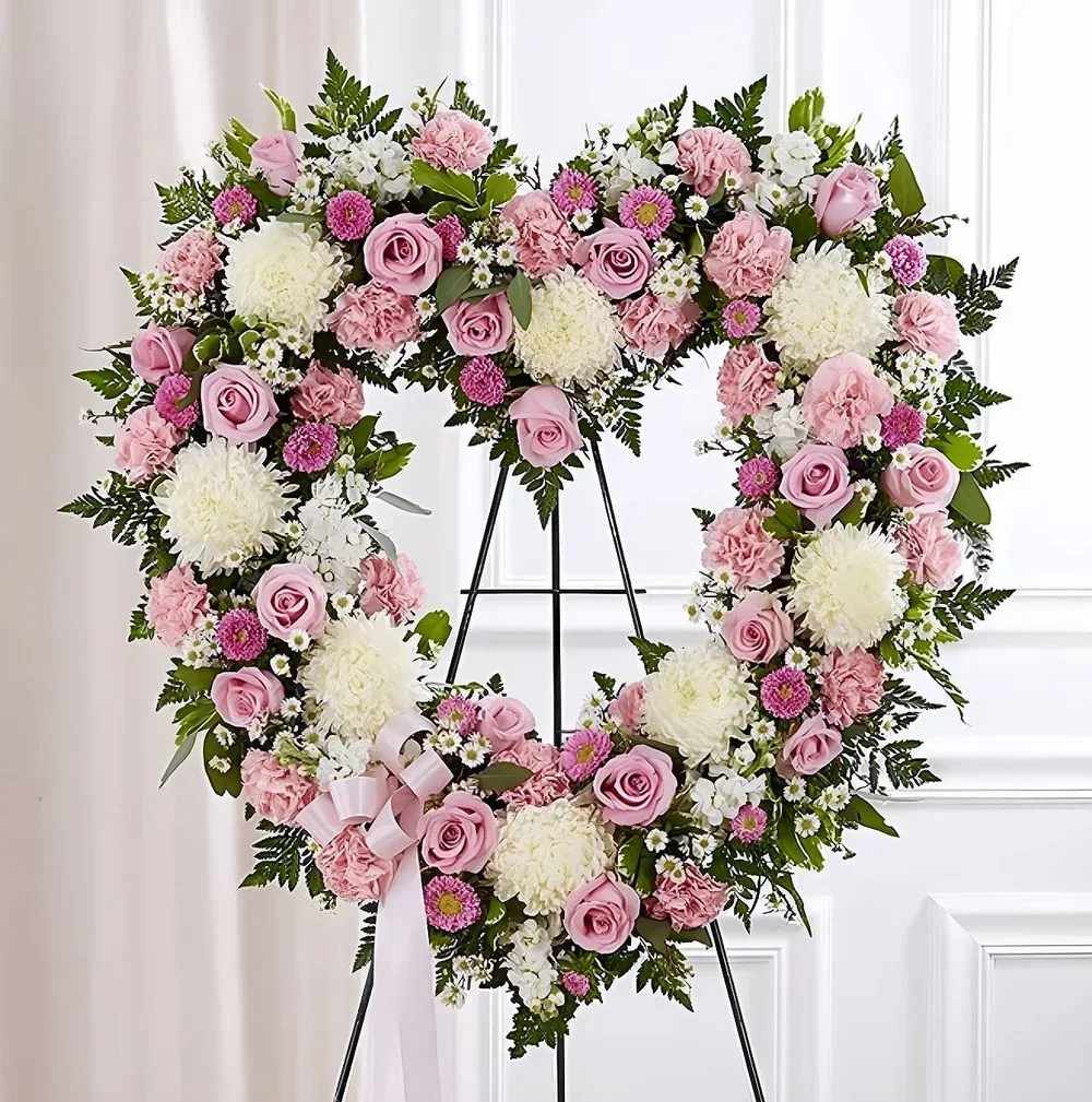Open Hearth Rose Open Hearth Rose - Crafted in the shape of an open heart, this arrangement symbolizes enduring love. The ring of flowers offers a tender way to remember cherished moments. Displayed on an easel, it shares a heartfelt message of remembrance.